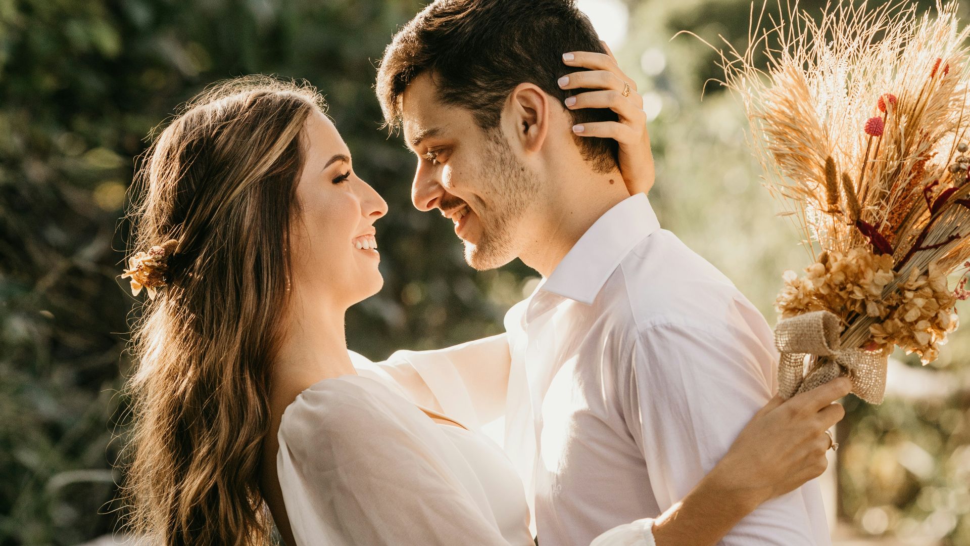 man in white dress shirt holding brown flower bouquet