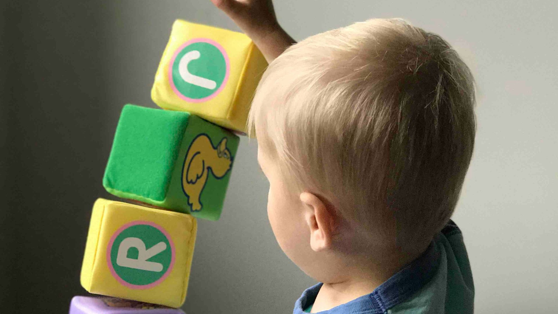 boy playing cube on white wooden table