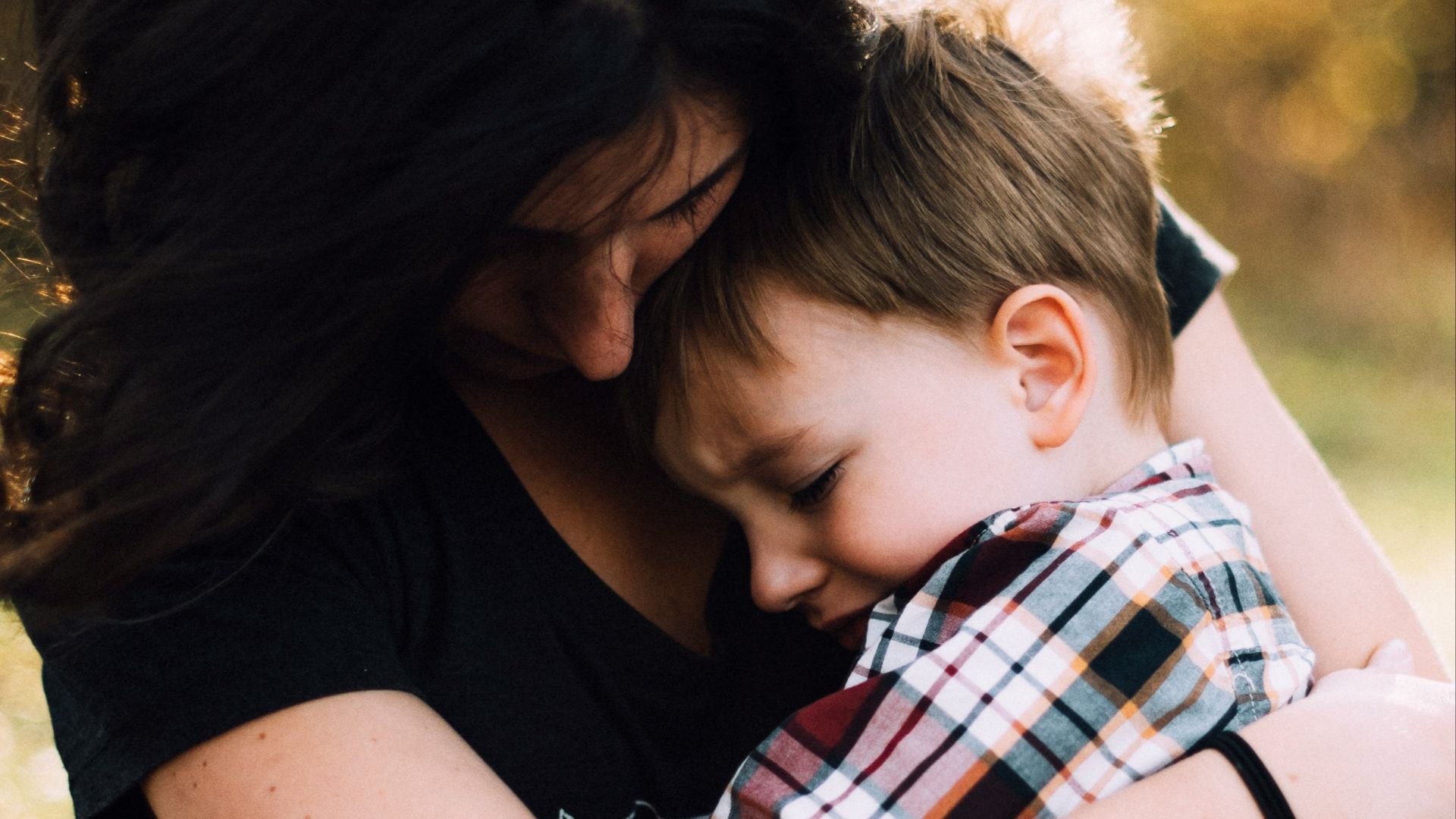 woman hugging boy on her lap