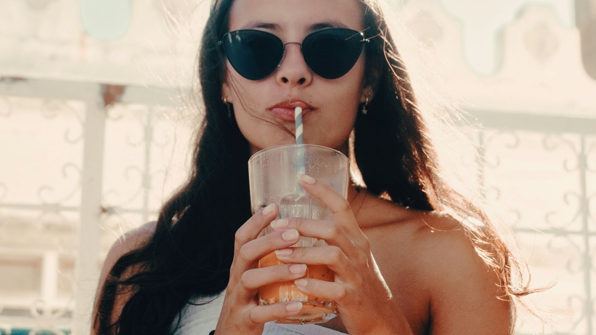 woman sipping straw in glass