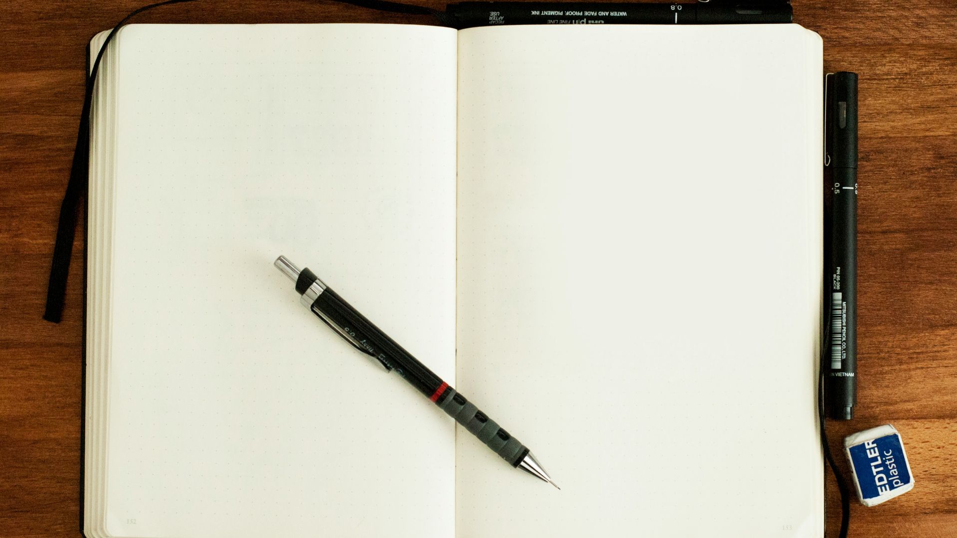 black and silver retractable pen on blank book