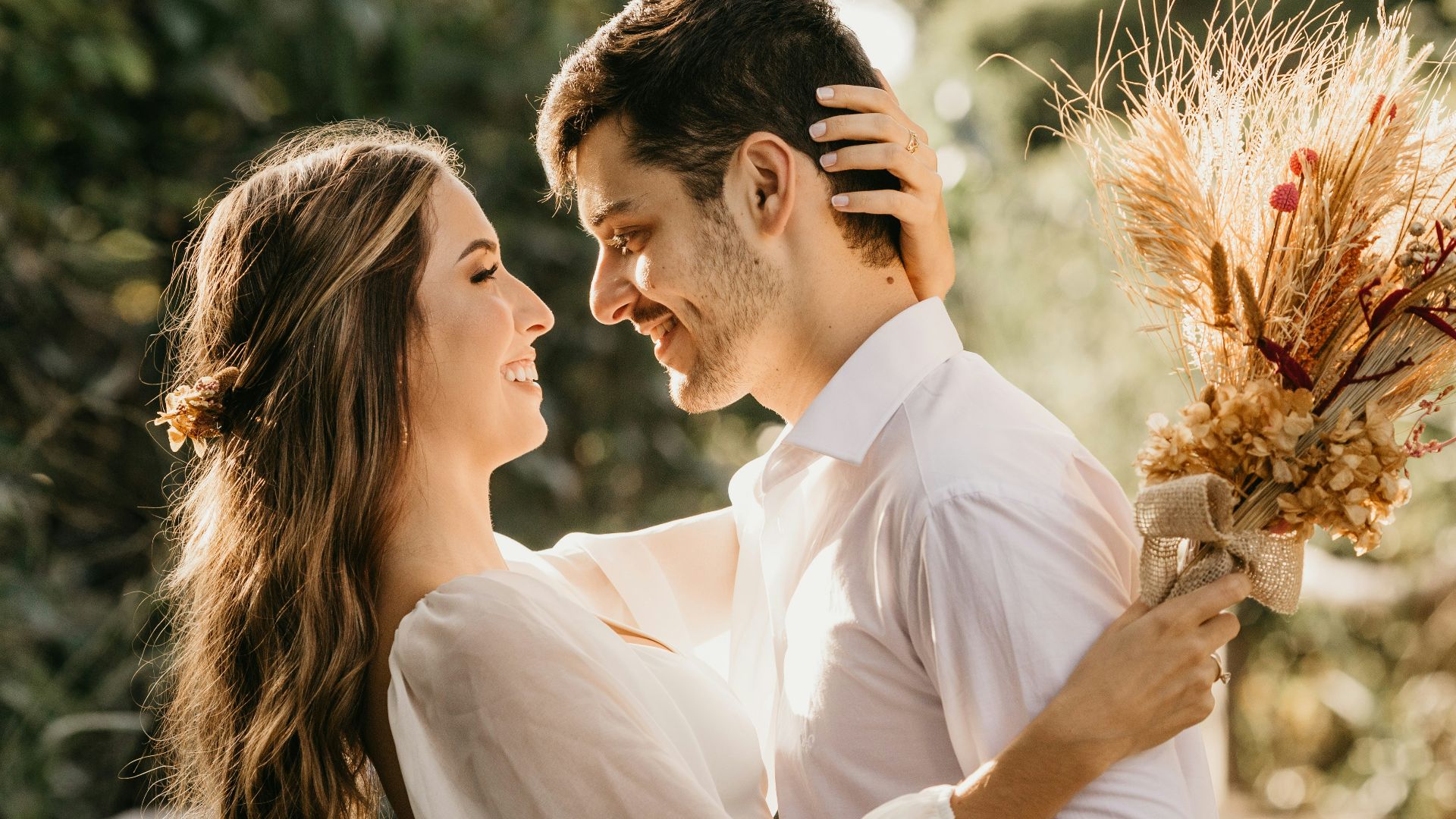man in white dress shirt holding brown flower bouquet
