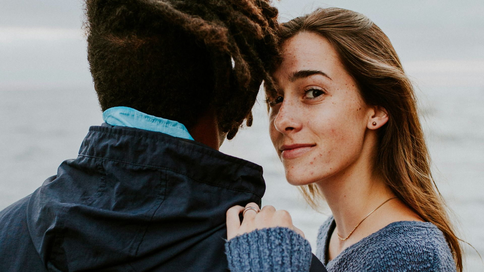 woman in blue long sleeve shirt beside woman in gray long sleeve shirt