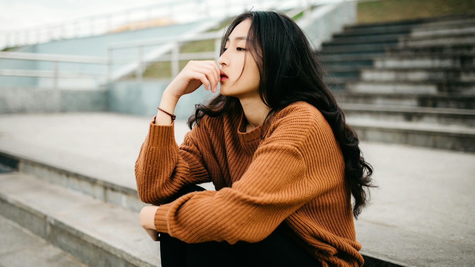 woman wearing brown sweater holding lips