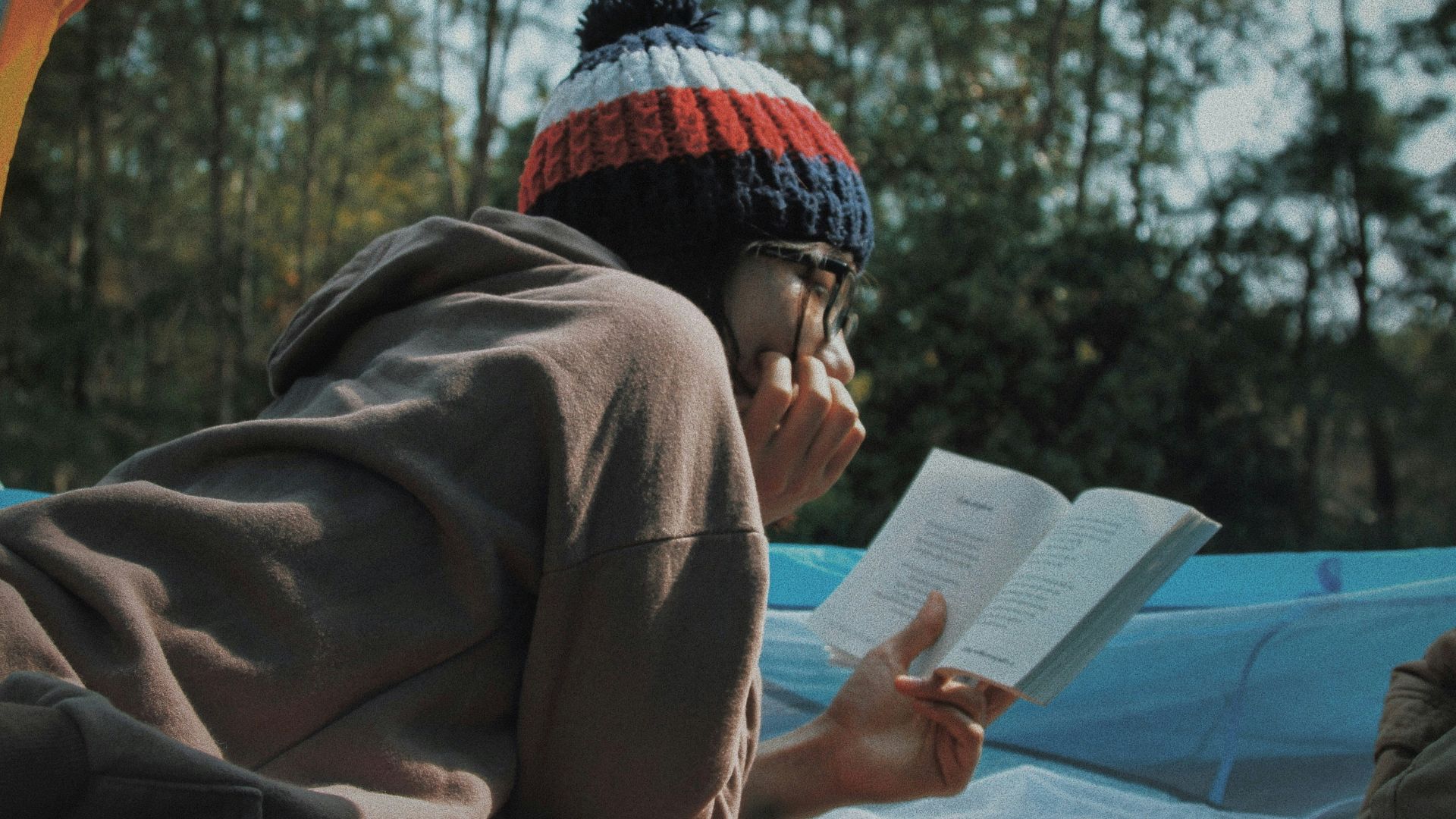 woman reading book in tent