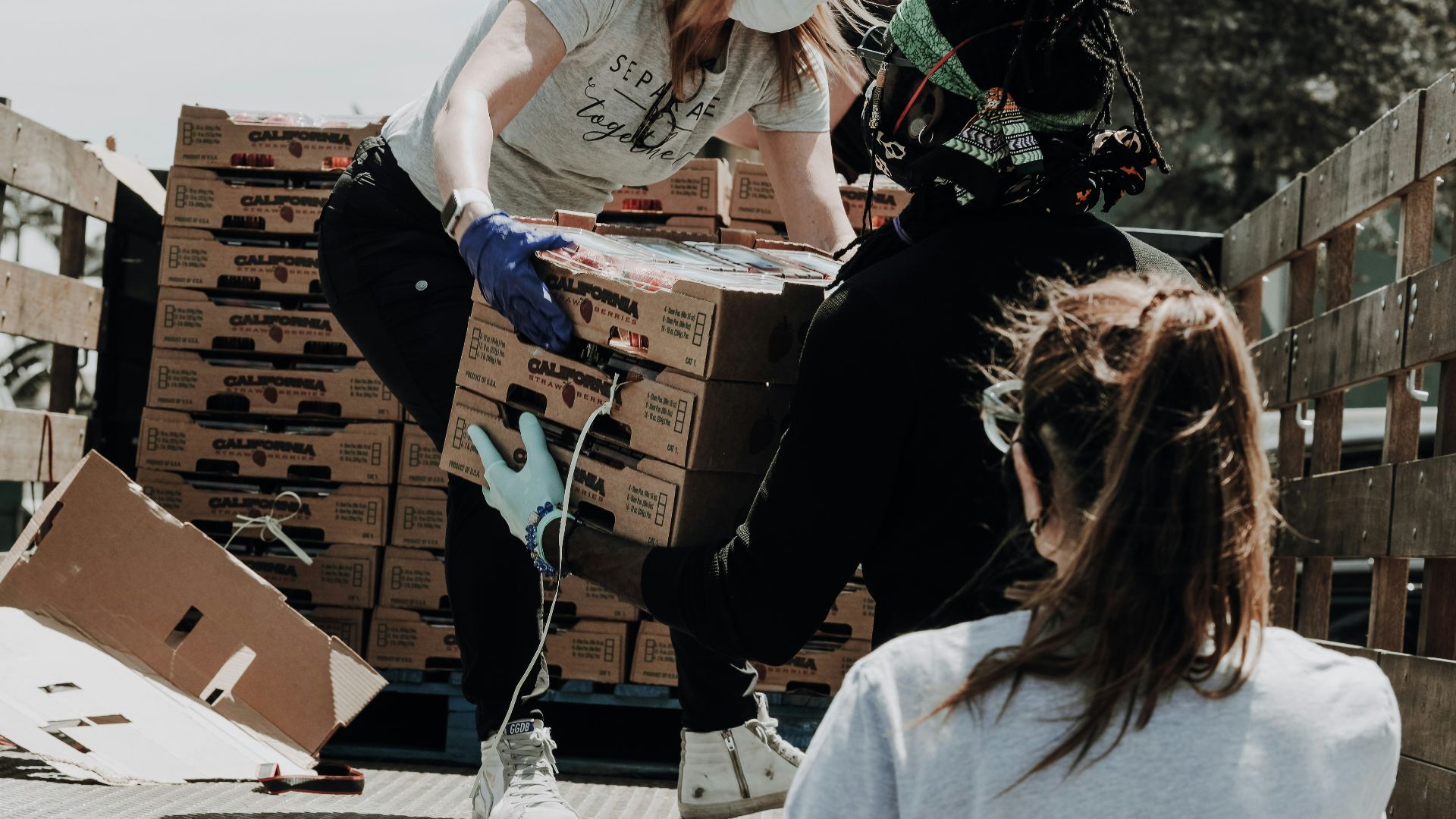 woman in white t-shirt and blue denim jeans sitting on brown cardboard box