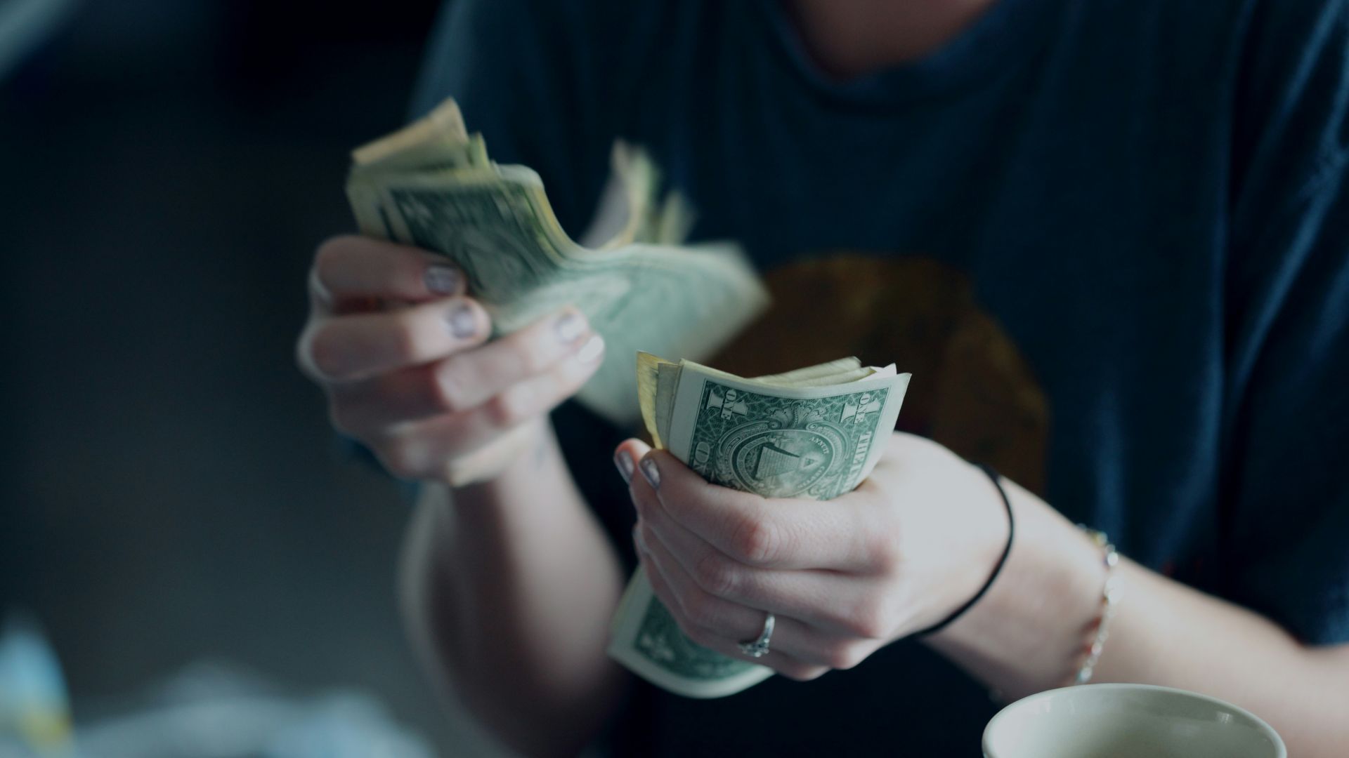 focus photography of person counting dollar banknotes