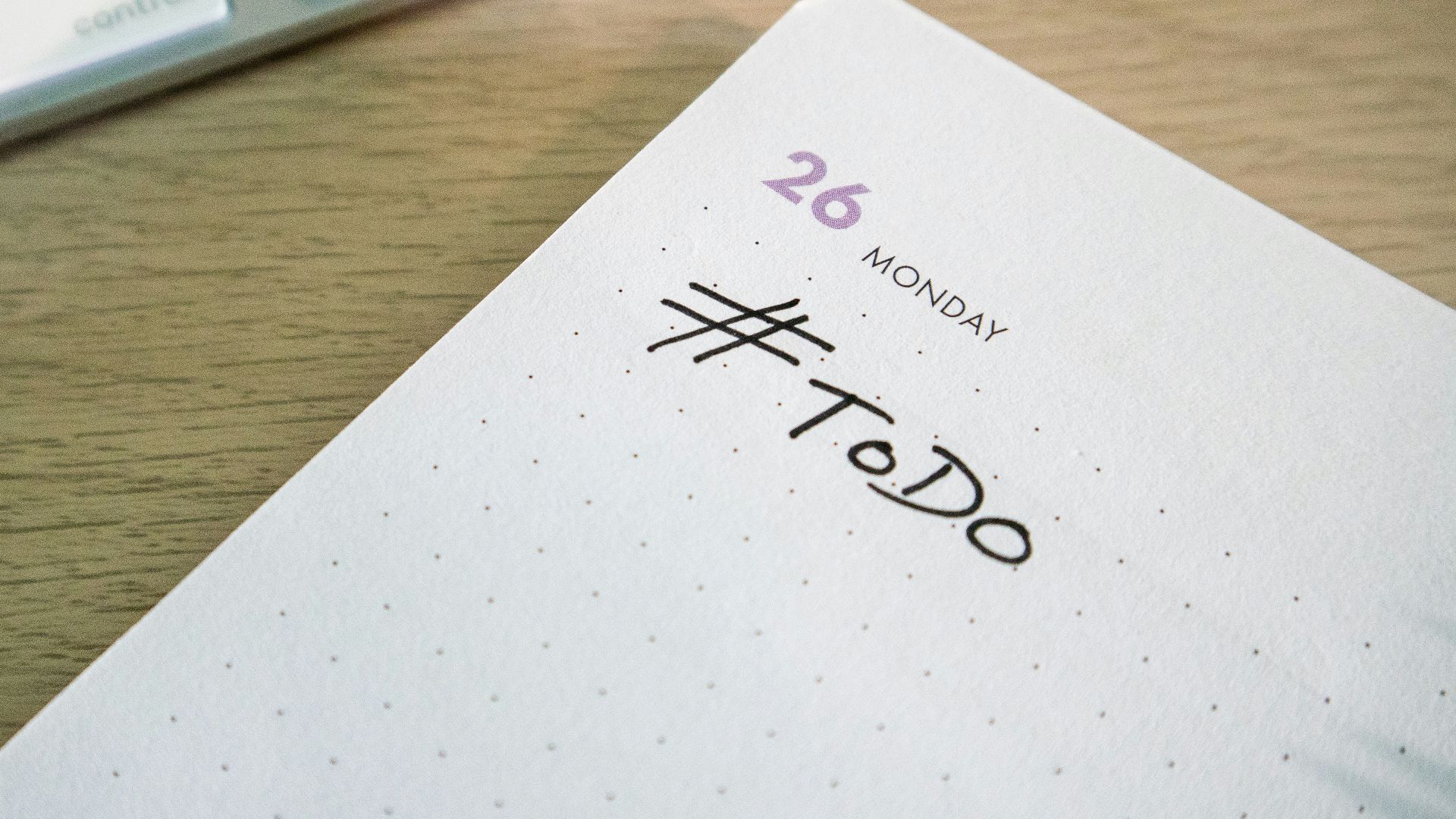 a close up of a notepad with a keyboard in the background