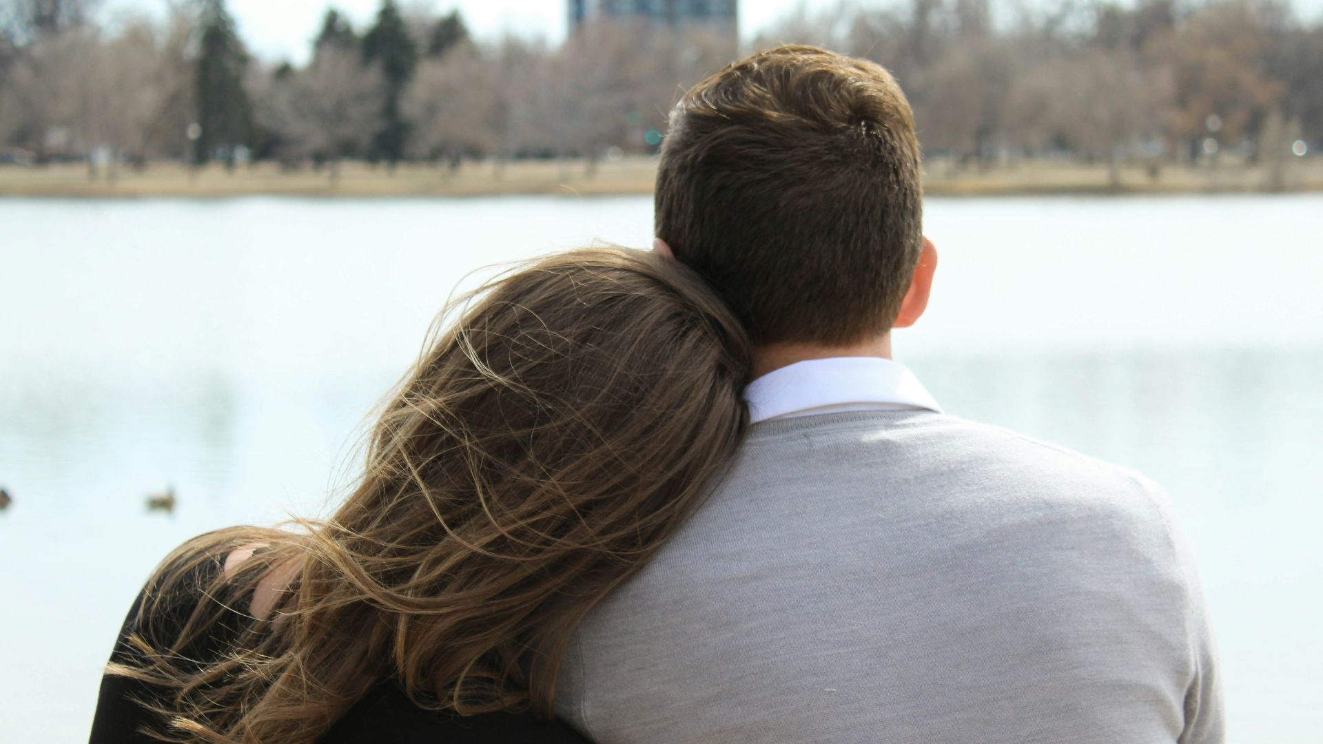 woman leaning head on man's shoulder