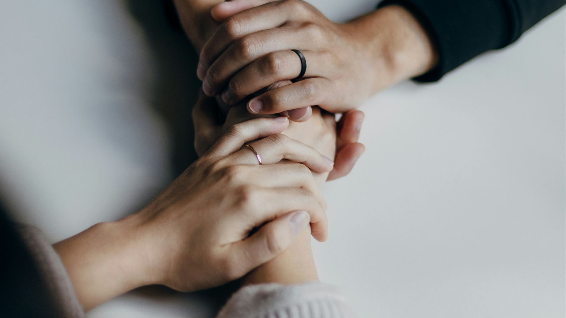 person in black long sleeve shirt holding babys feet