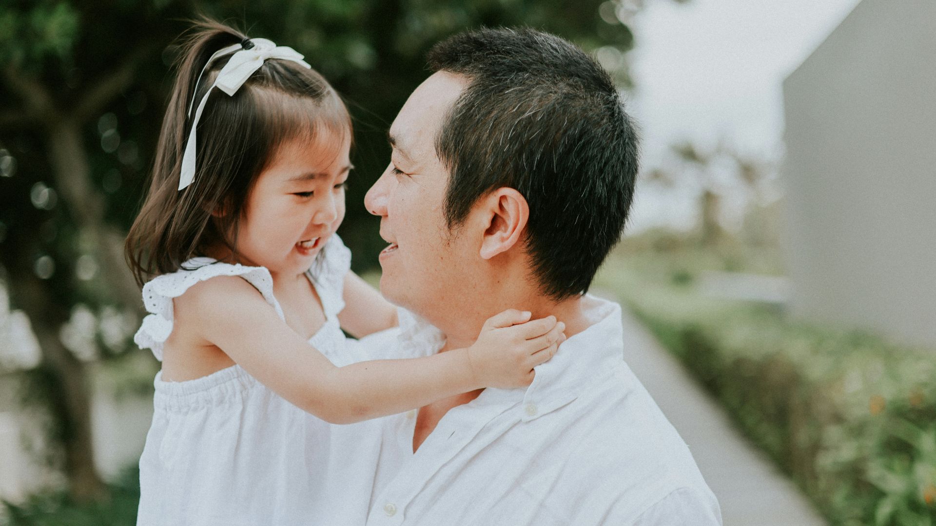 Father holds his young daughter outdoors