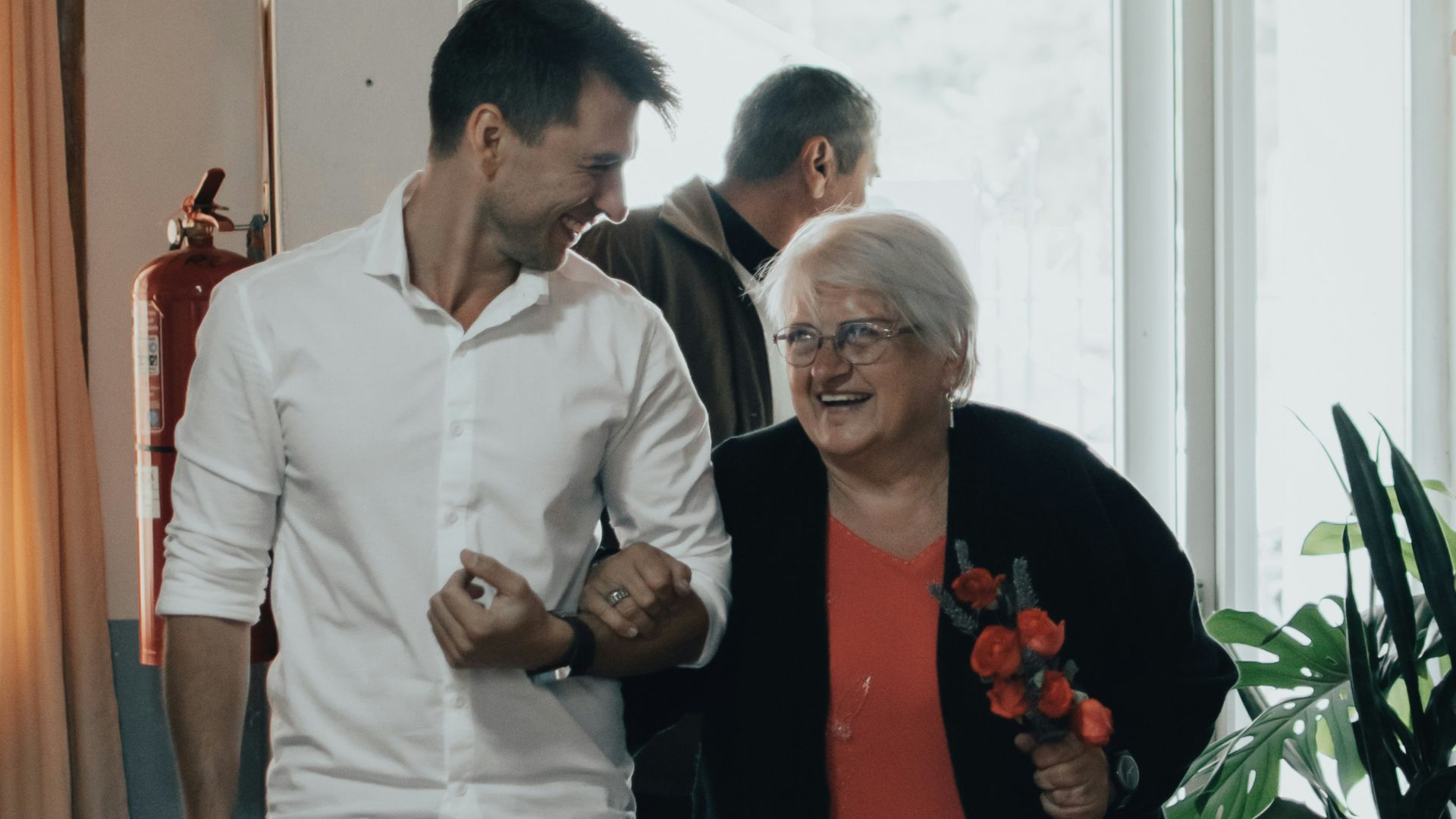 man in white dress shirt standing beside woman in red long sleeve shirt