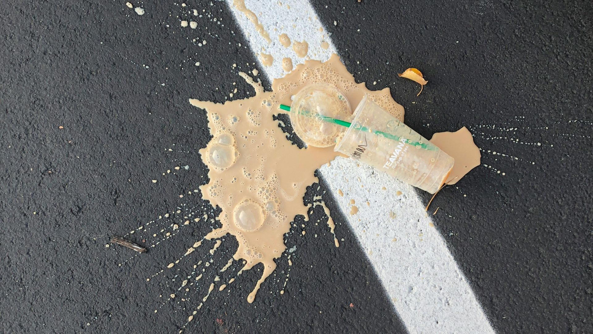 person standing on white line with cup on ground