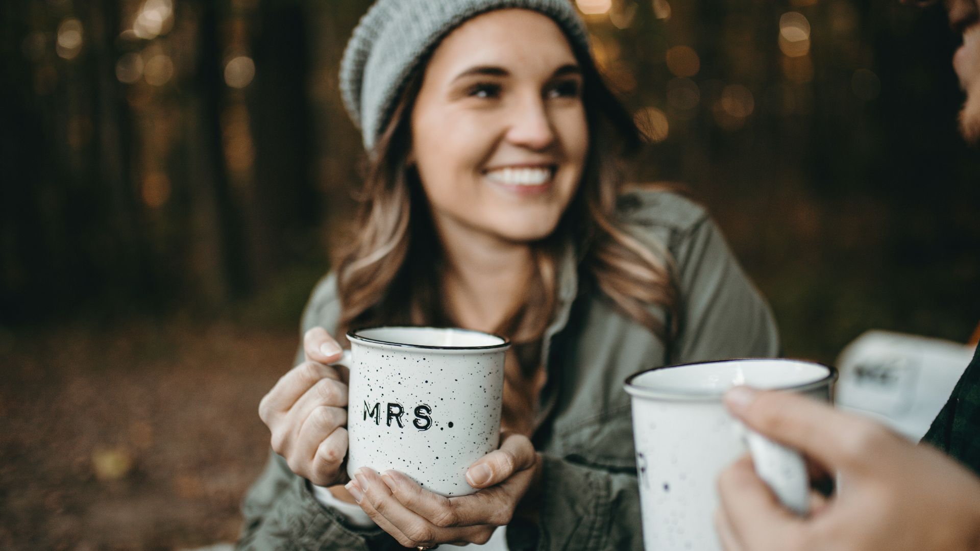 woman holding white mugs