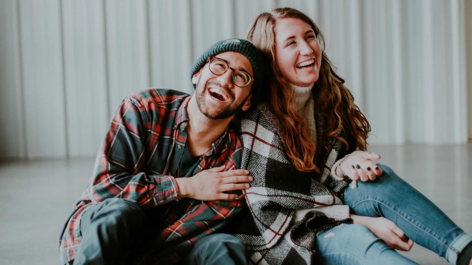 smiling woman and man sitting on floor