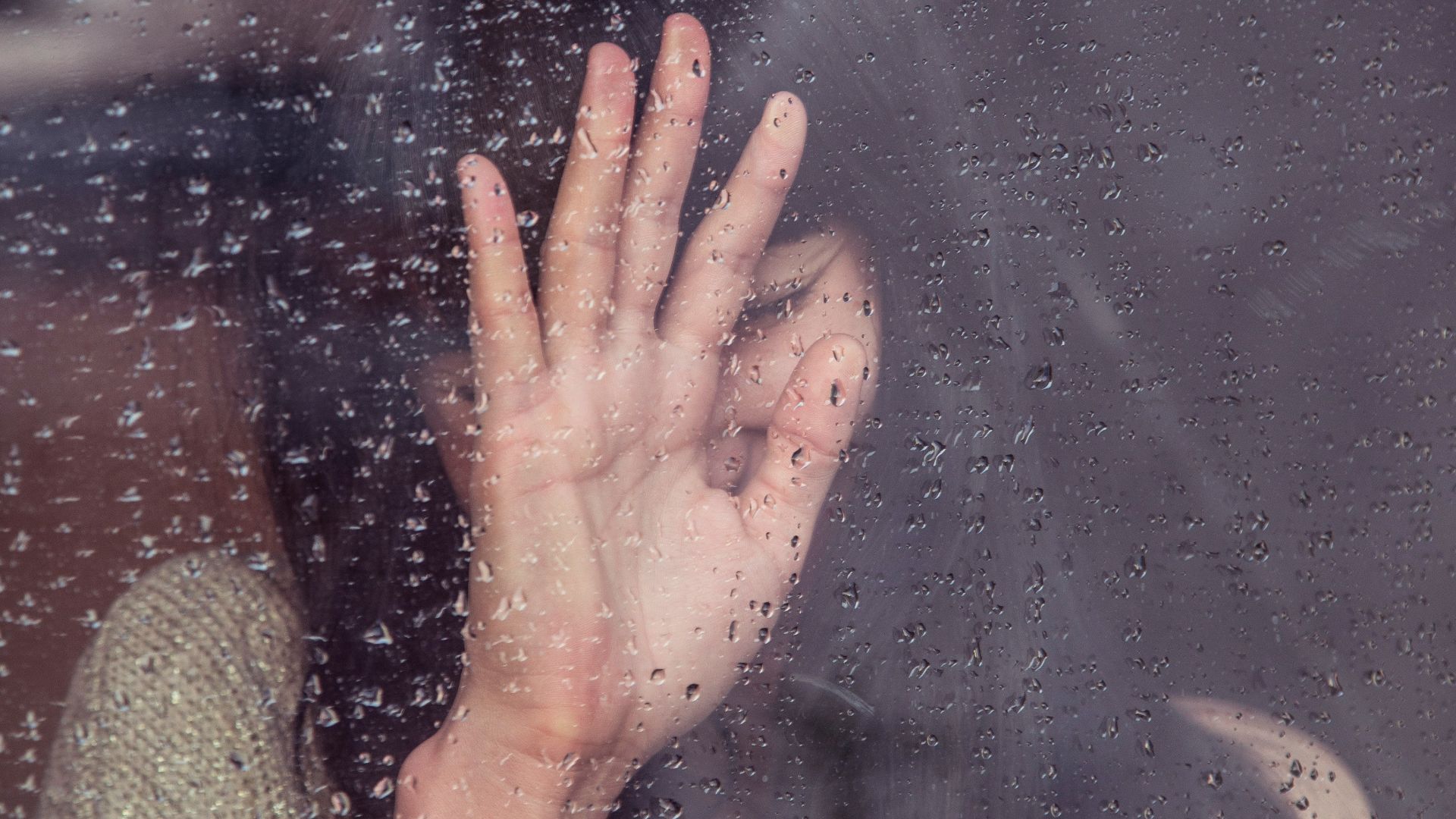 woman touch rainy glass