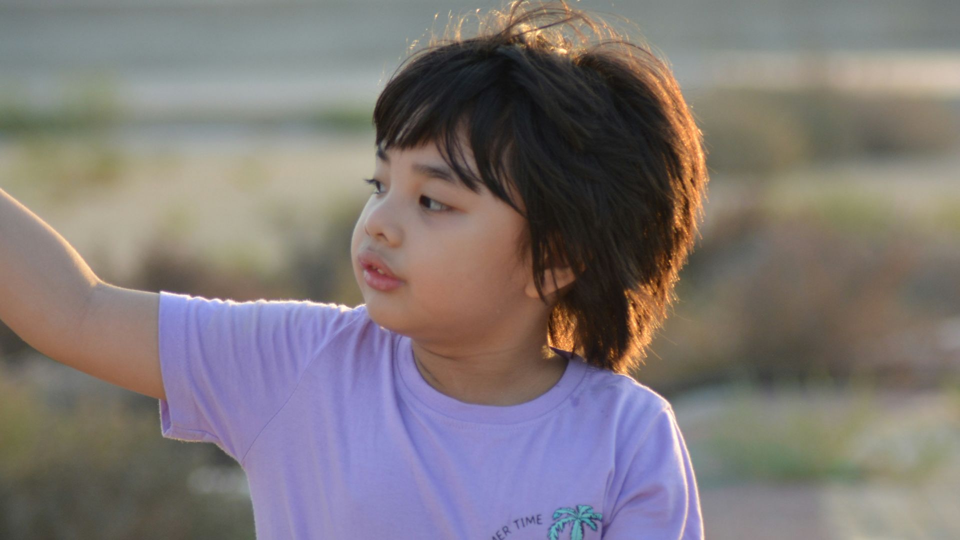 A young boy holding a yellow frisbee in his hand