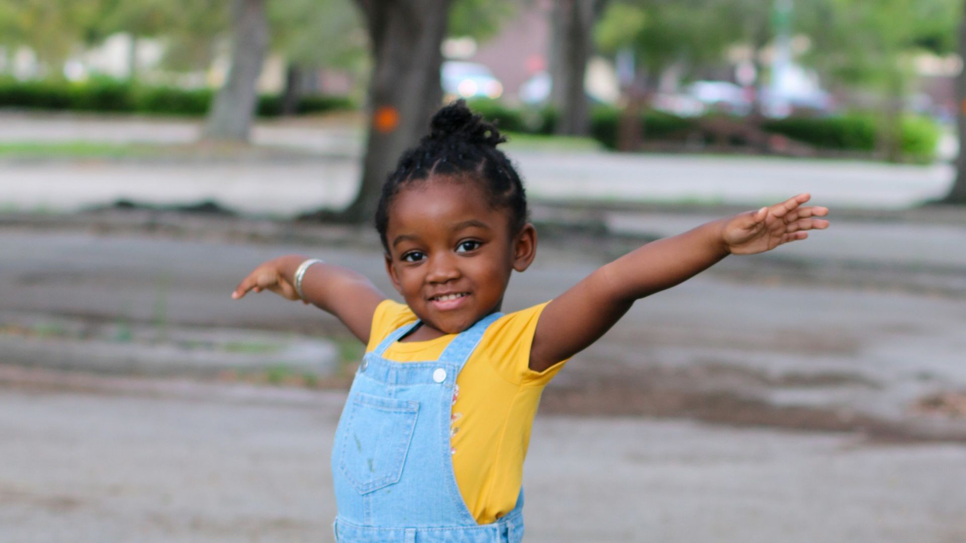 girl in yellow shirt standing on gray concrete blocks during daytime