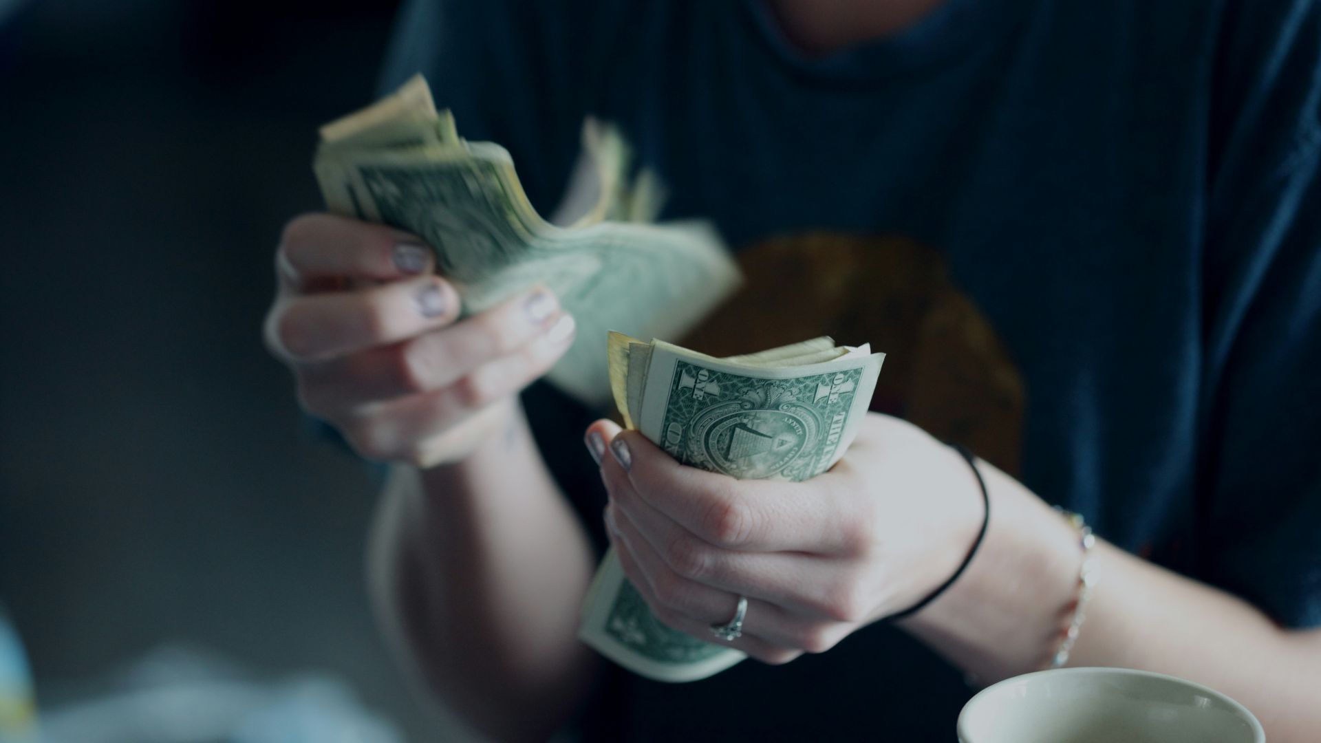 focus photography of person counting dollar banknotes