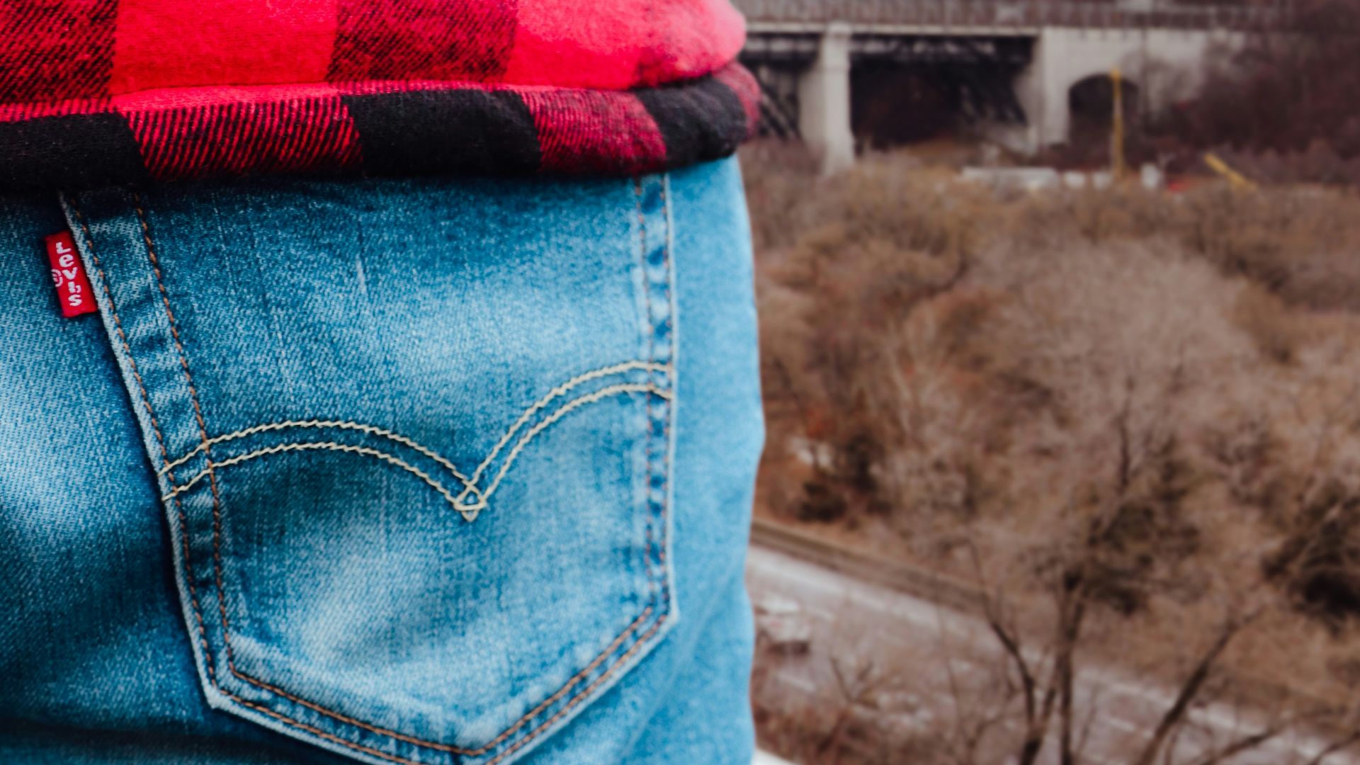 unknown person in red and black top and blue denim bottoms