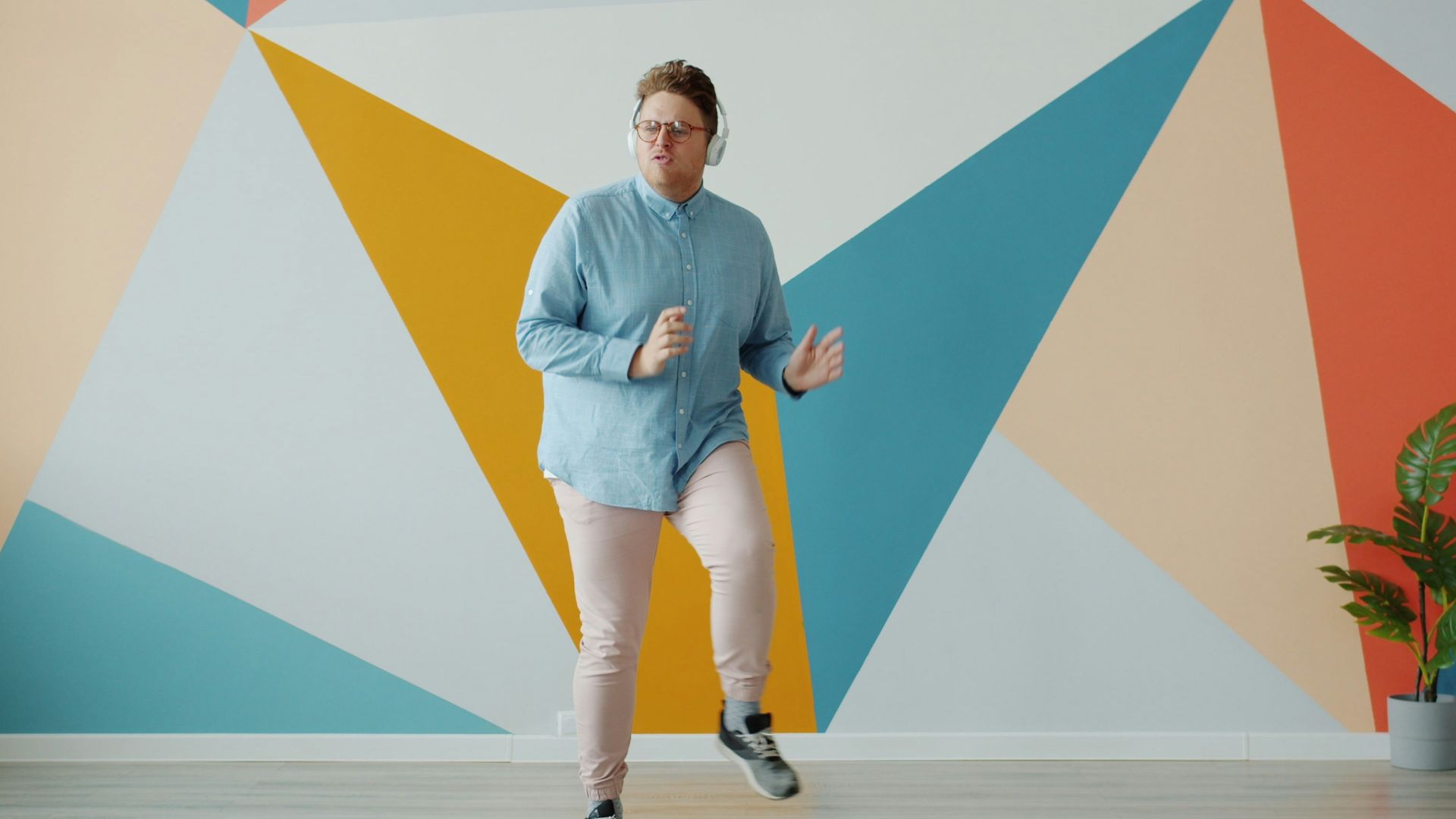 Person exercising in front of a colorful geometric wall