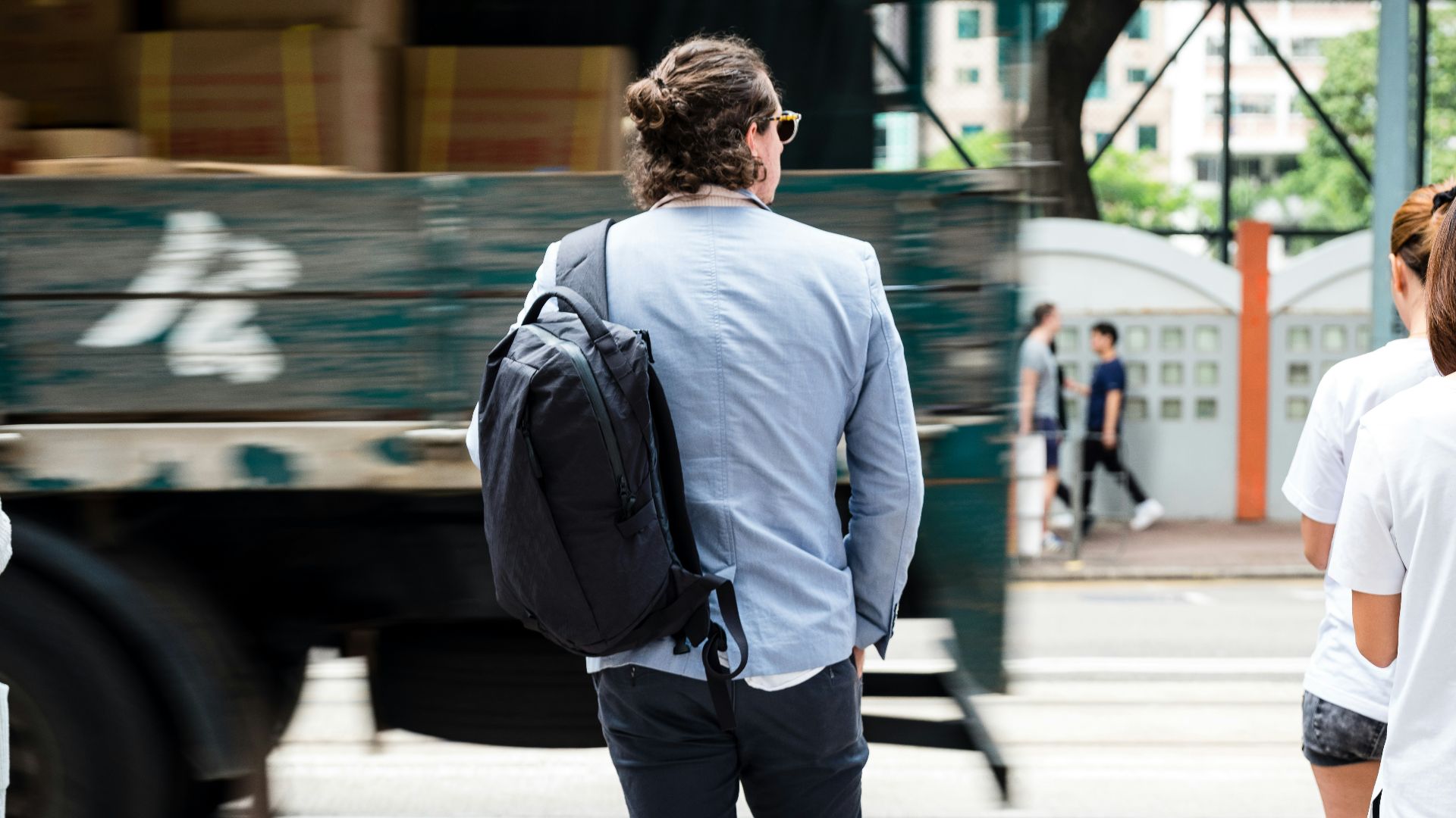 man in blue suit walking on sidewalk during daytime