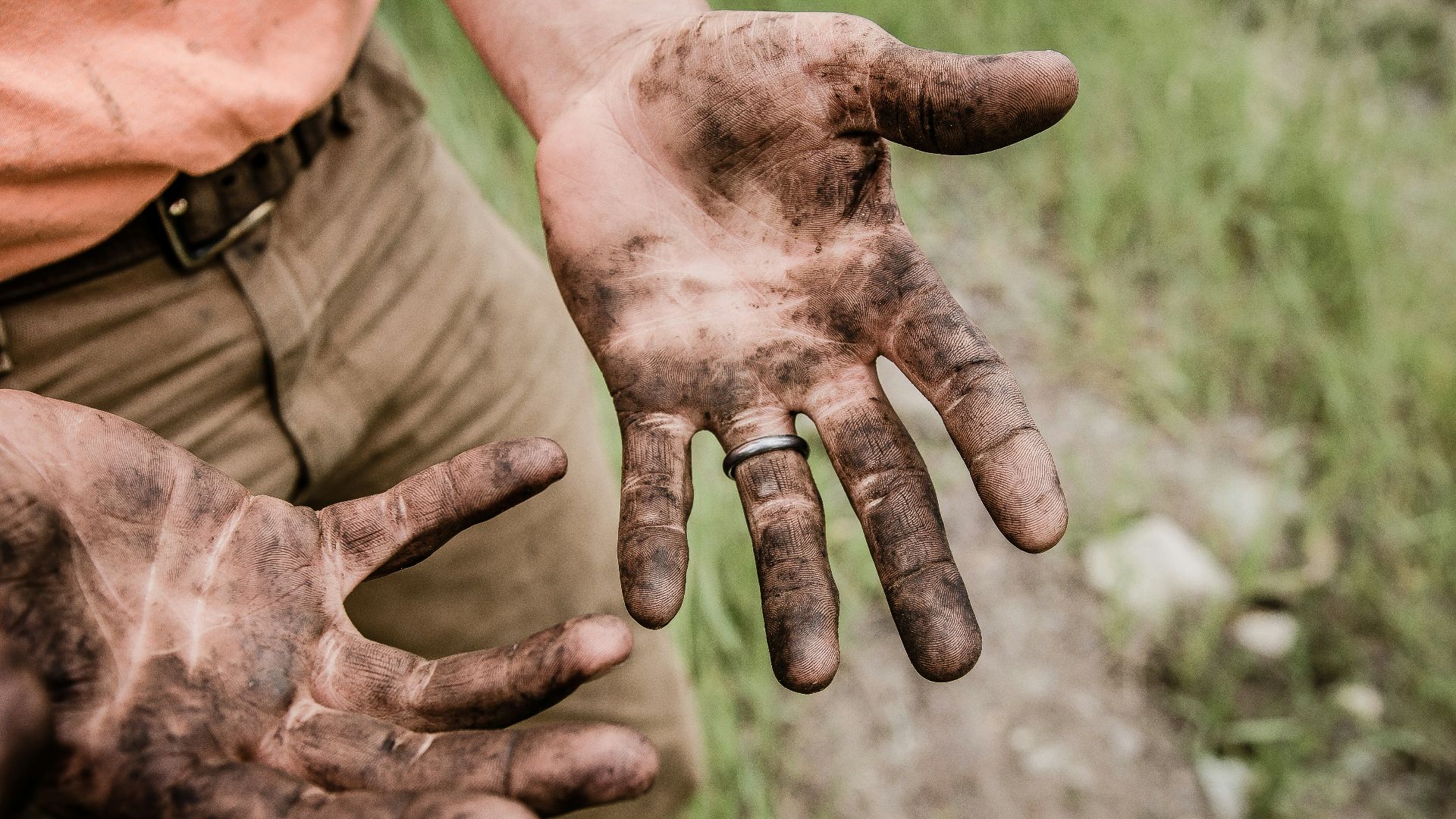 A man with his hands covered with mud