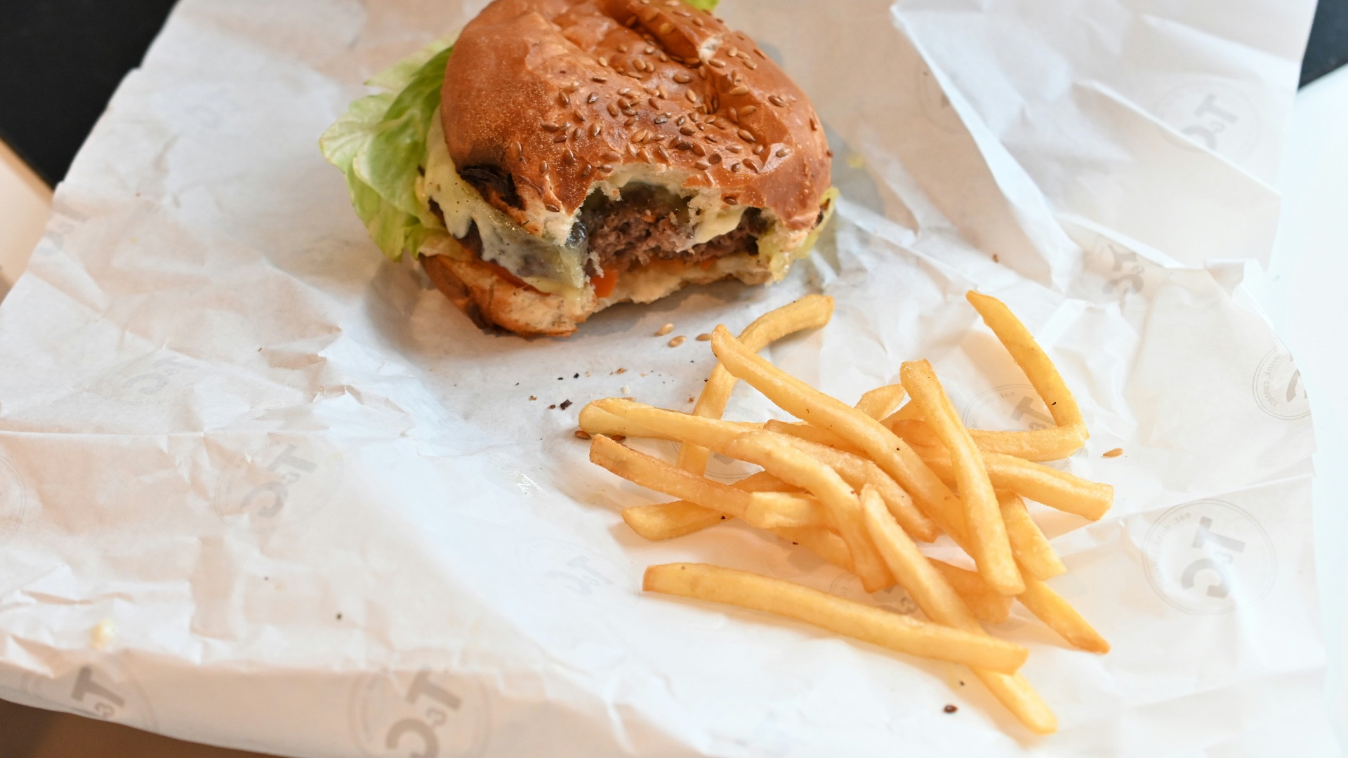 a hamburger and french fries sitting on a piece of paper