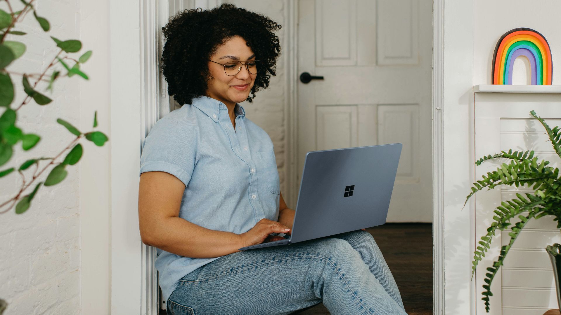 a woman sitting on the floor using a laptop