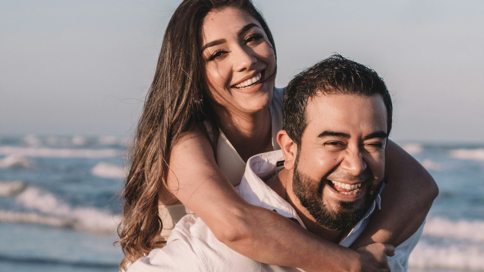 man in white dress shirt hugging woman in white dress