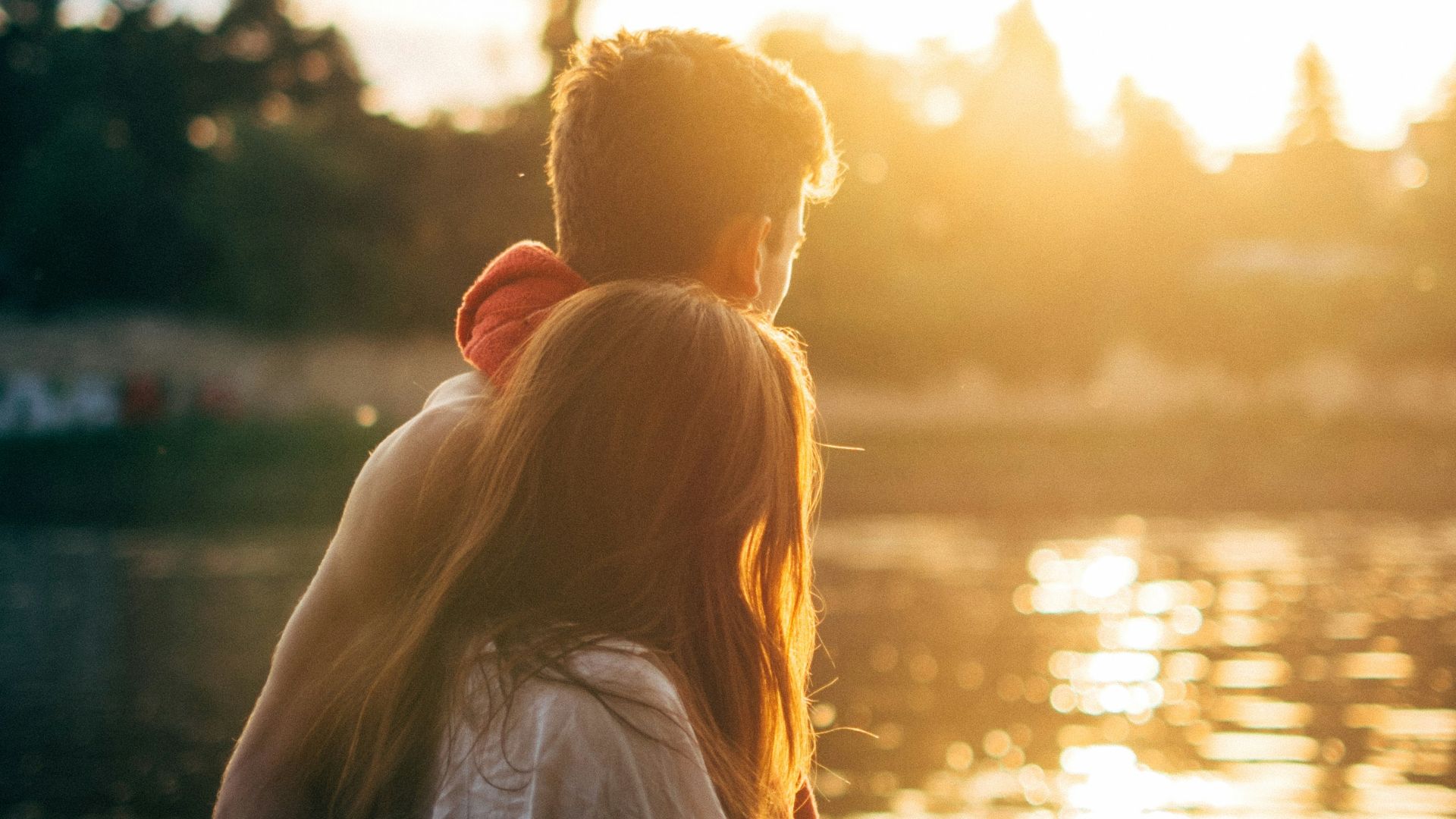 couple walking on lake side watching sunset close-up photo