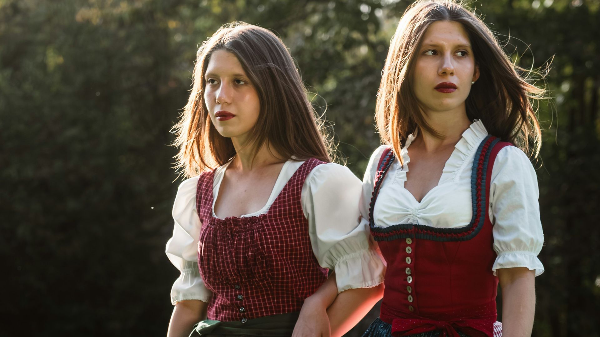 Two women in traditional bavarian dresses outdoors