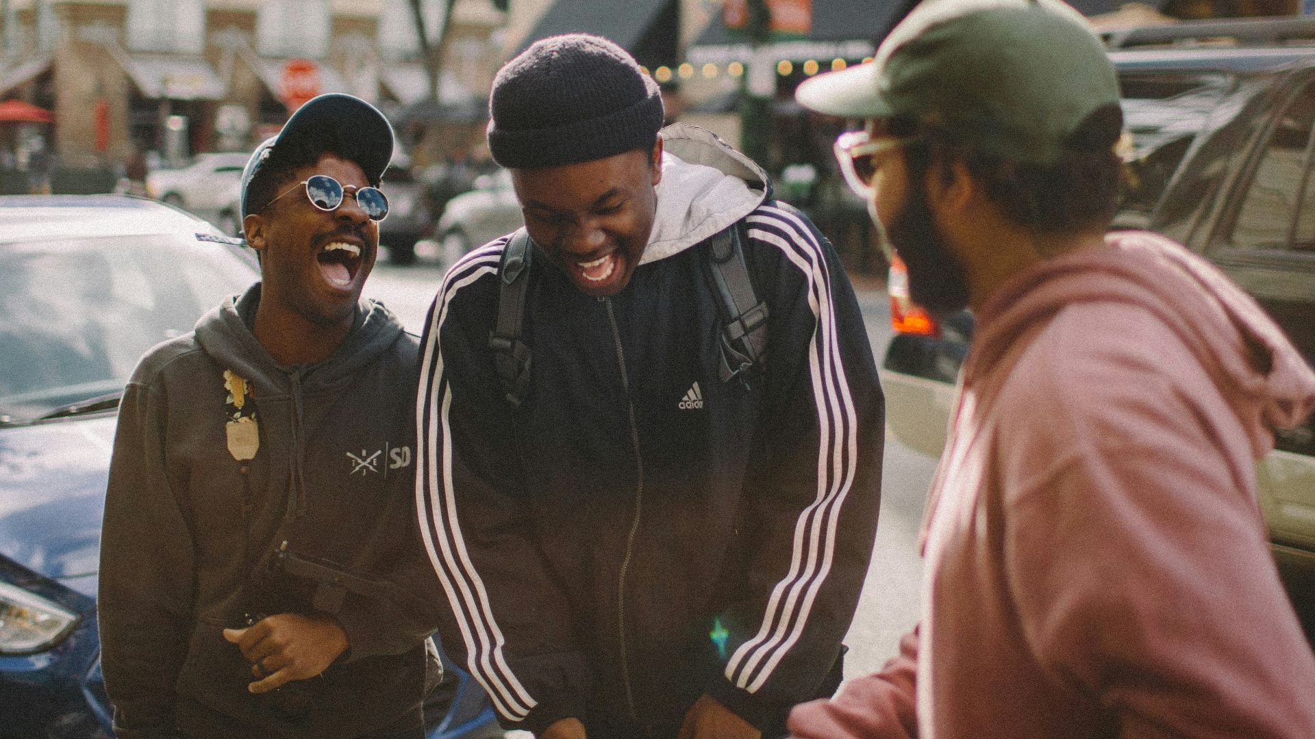 three men in jacket laughing at each other