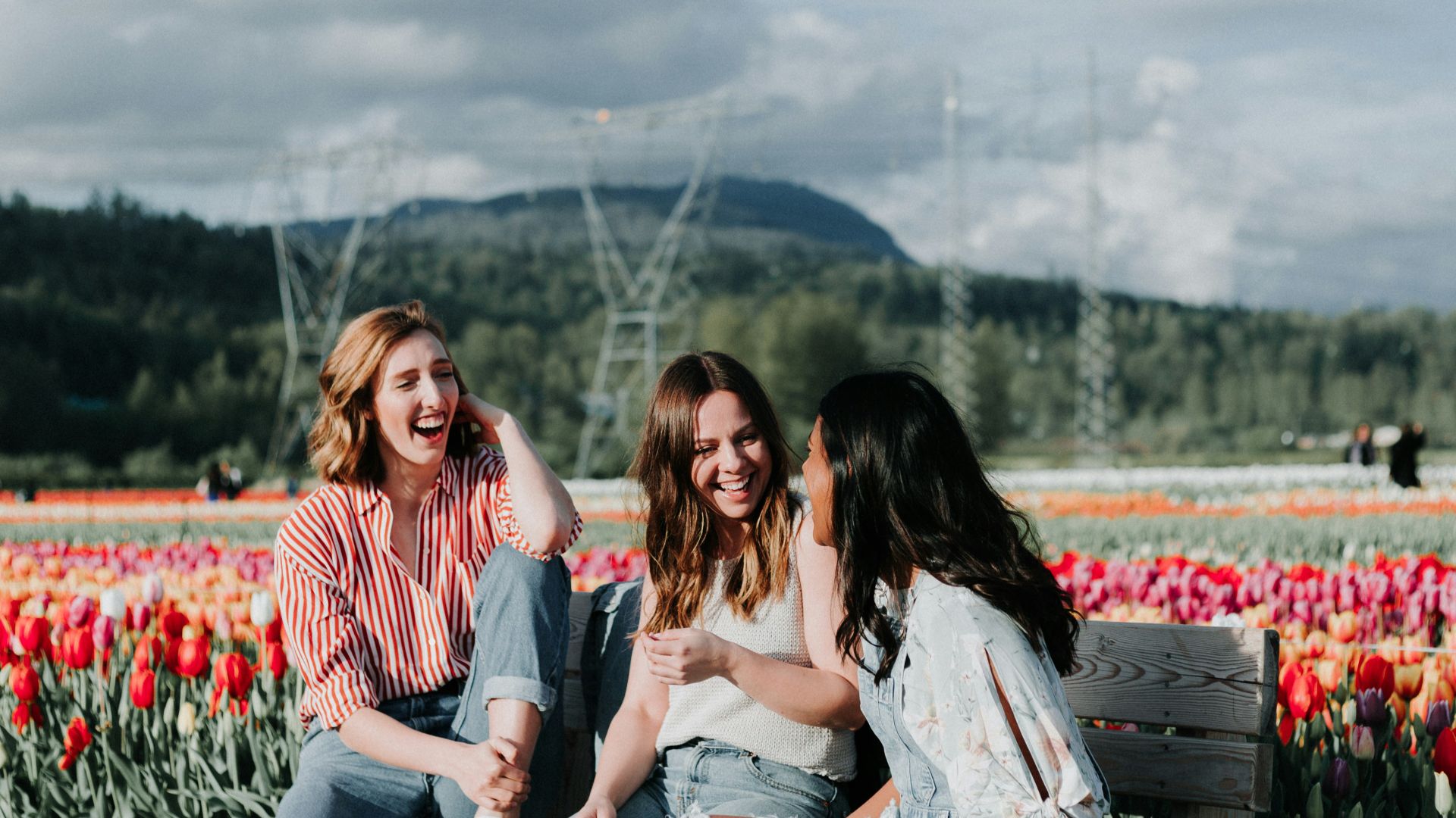 3 women sitting on bench near the flowers