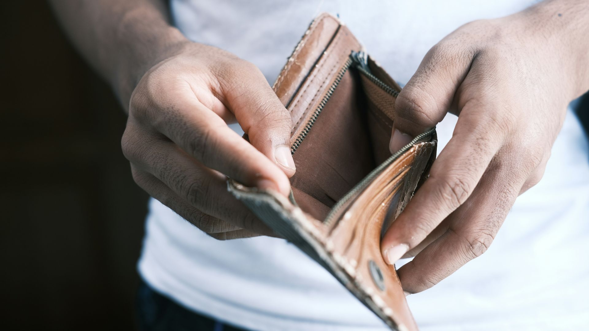 person holding brown leather bifold wallet
