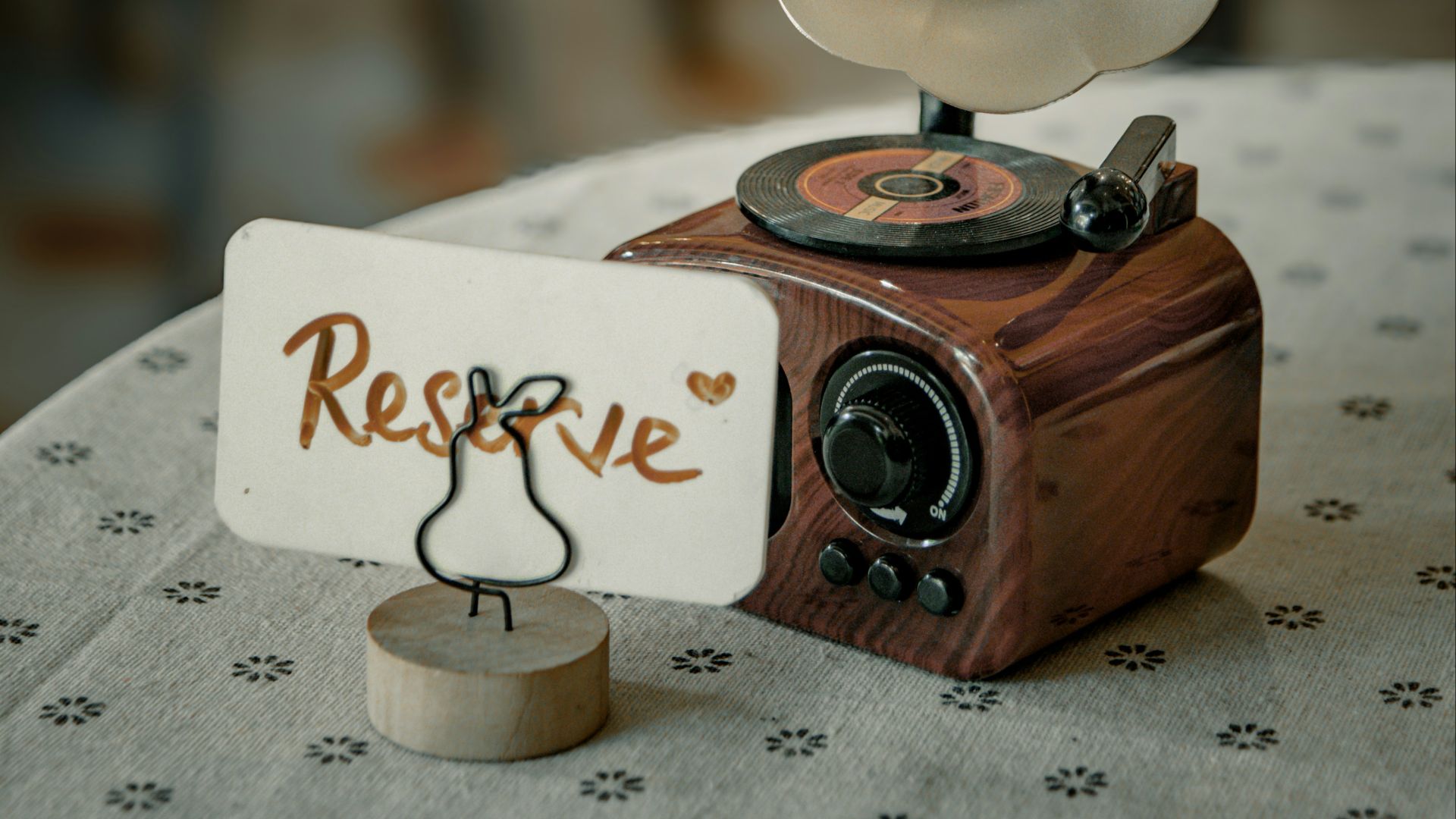 Vintage gramophone with 'reserve' sign on table