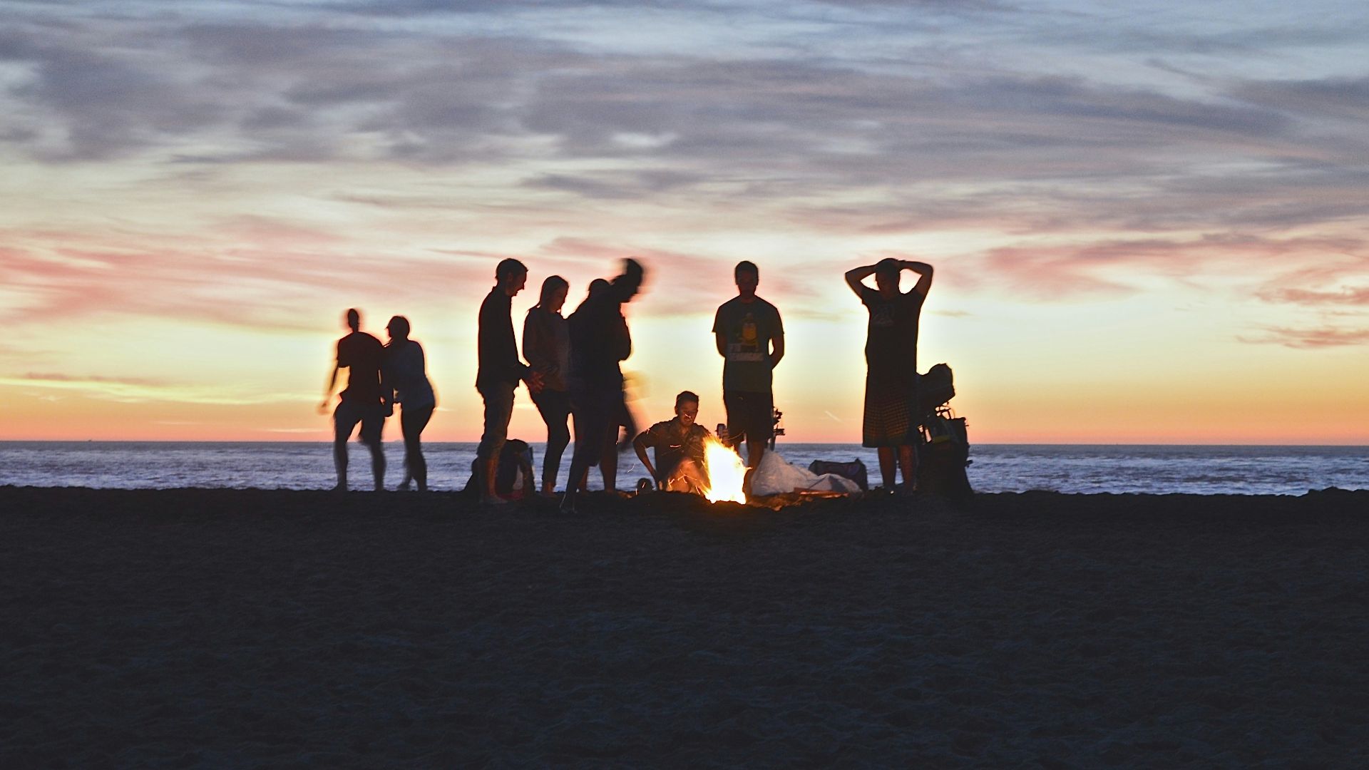 group of people setting up campfire