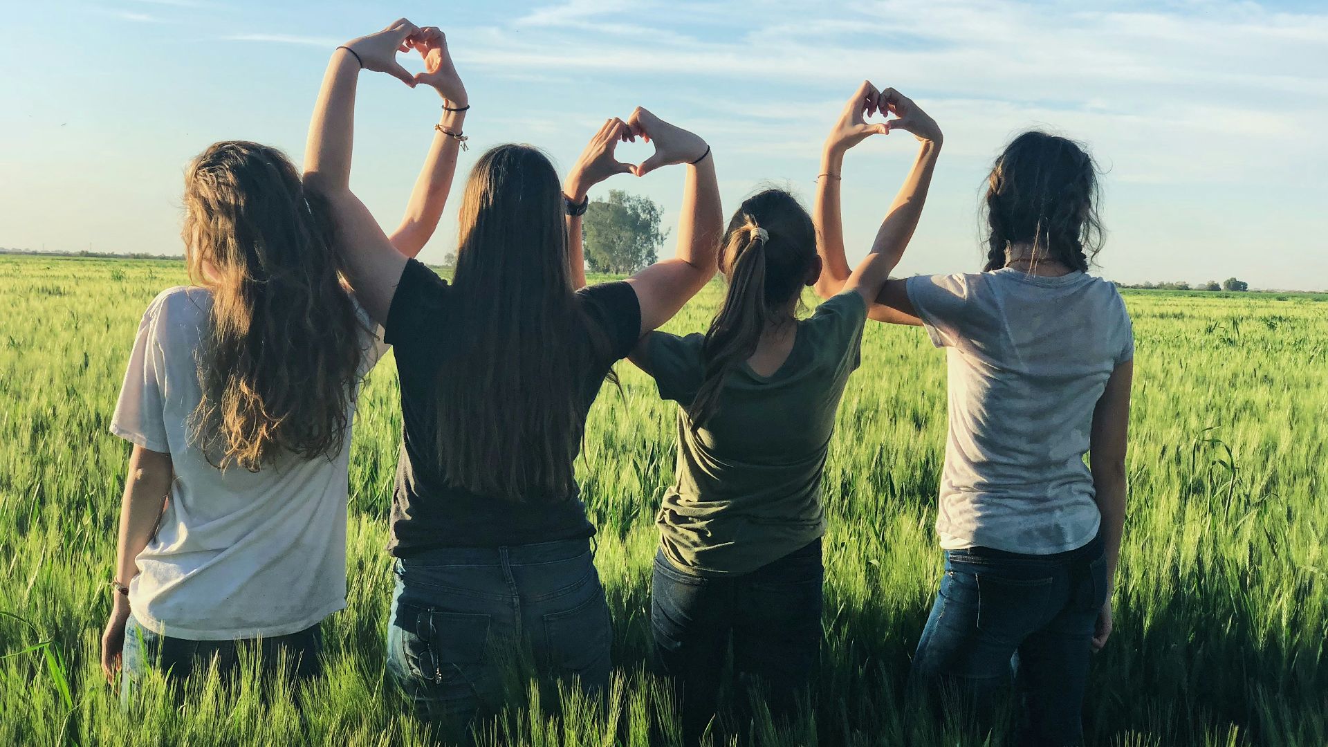 women forming heart gestures during daytime