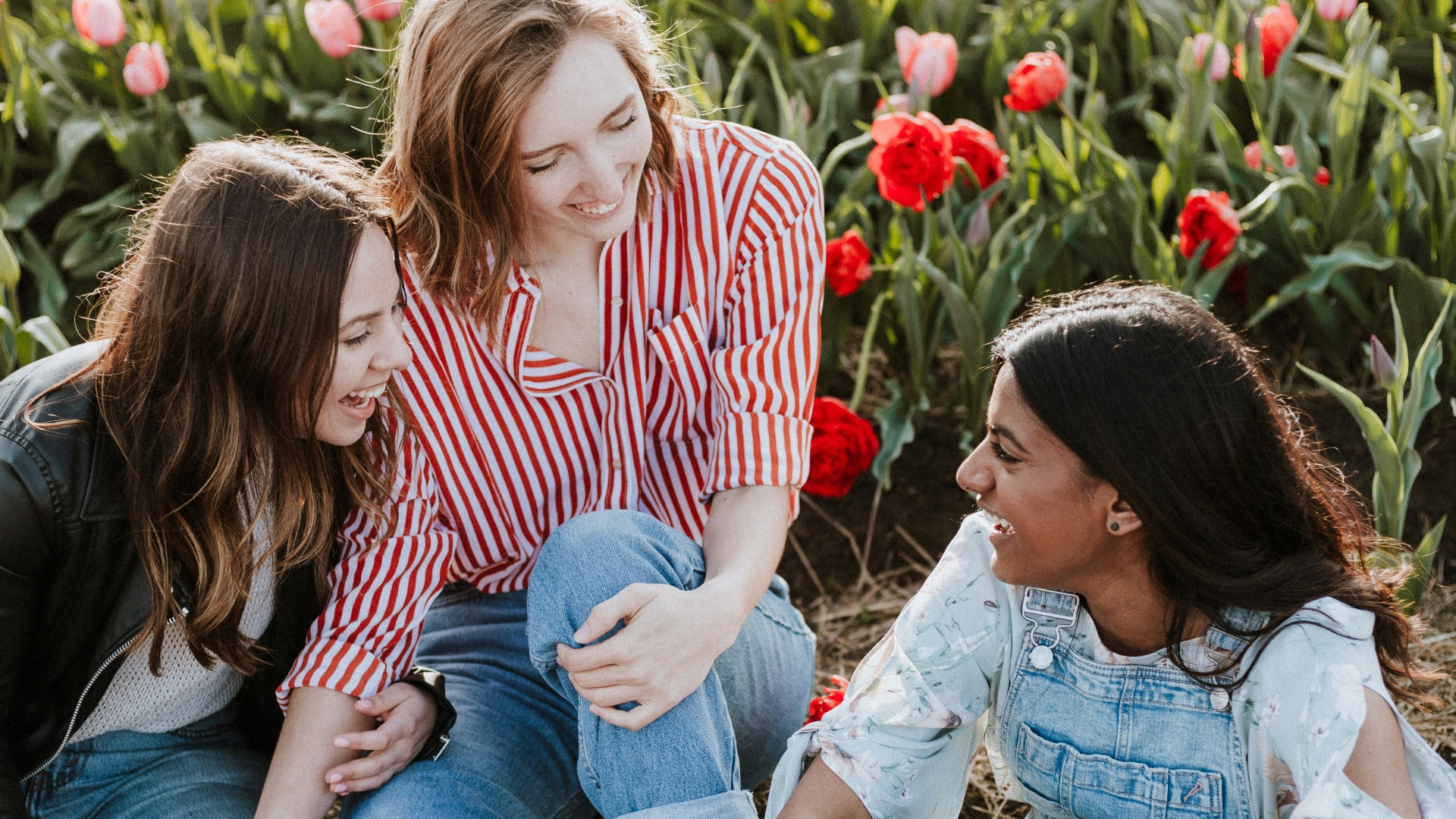 three woman sitting near the flower