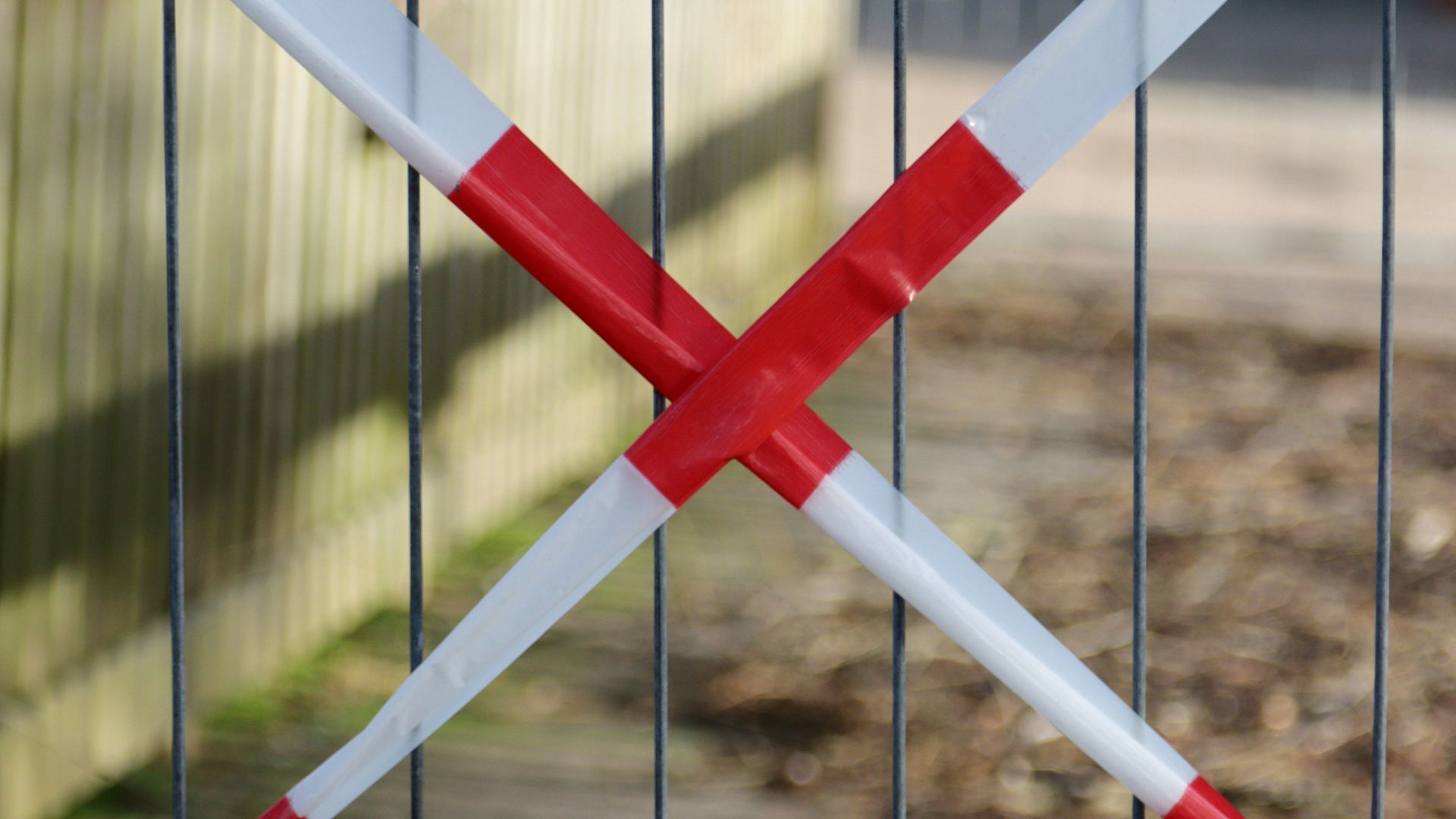 a fence with two red and white tape wrapped around it