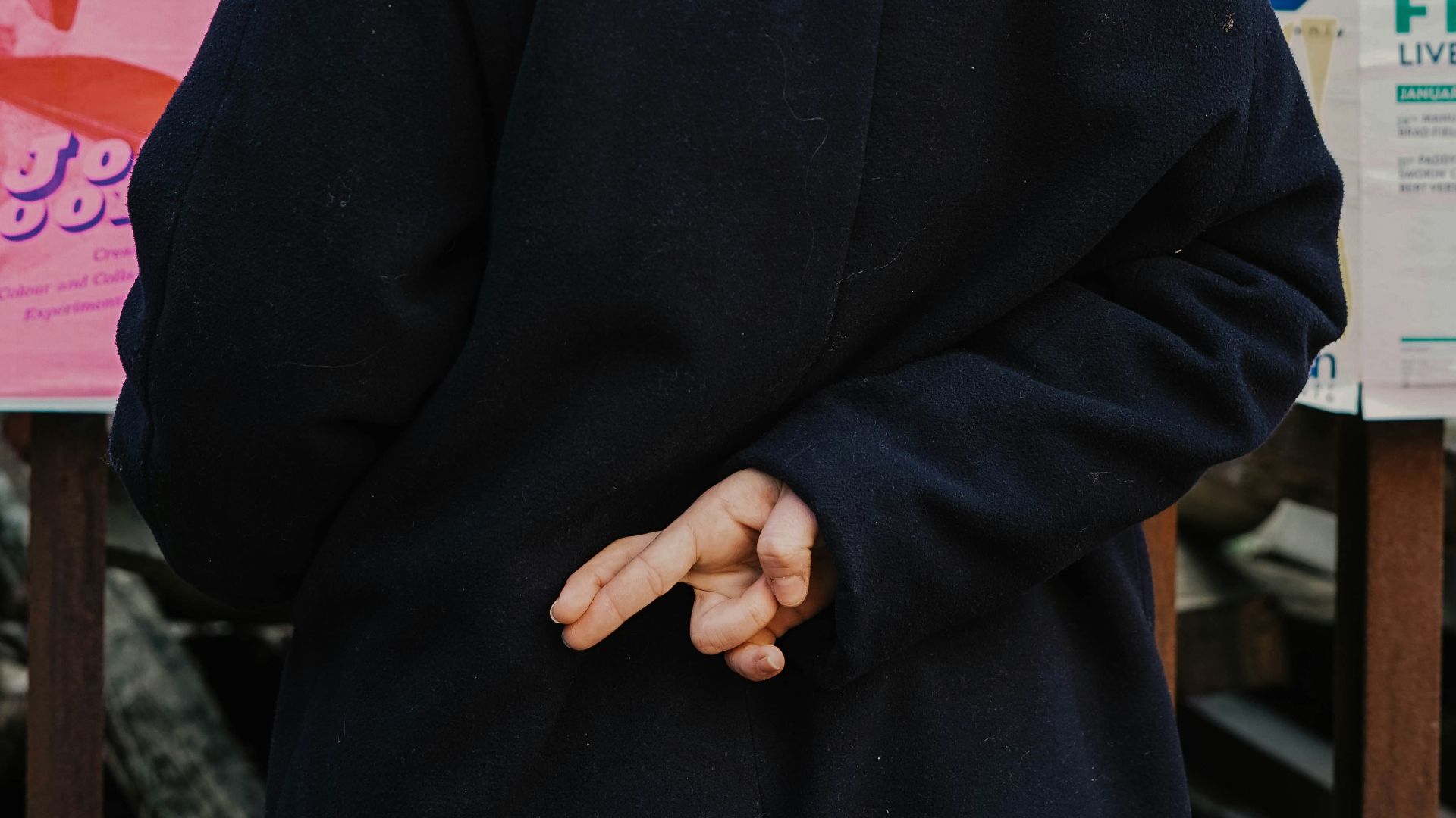 woman in blue hoodie standing in front of white and red kanji text signage