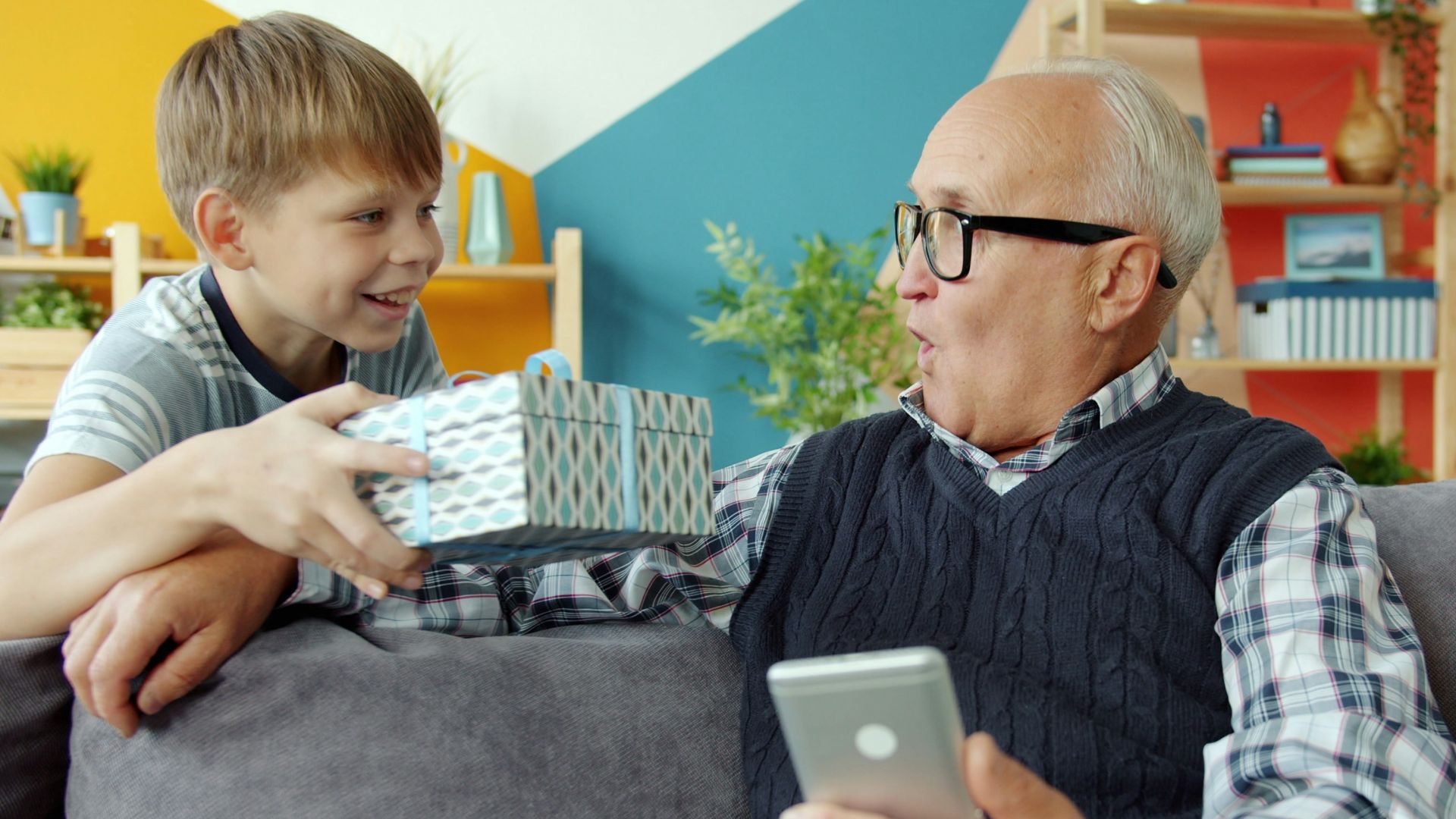 Boy gives surprised grandfather a gift