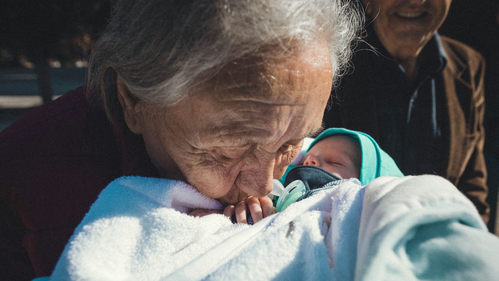 a woman holding a baby wrapped in a blanket