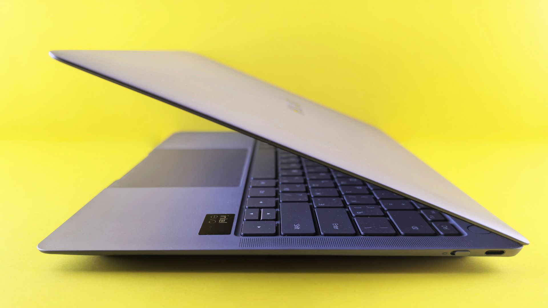 Silver laptop computer angled on yellow background