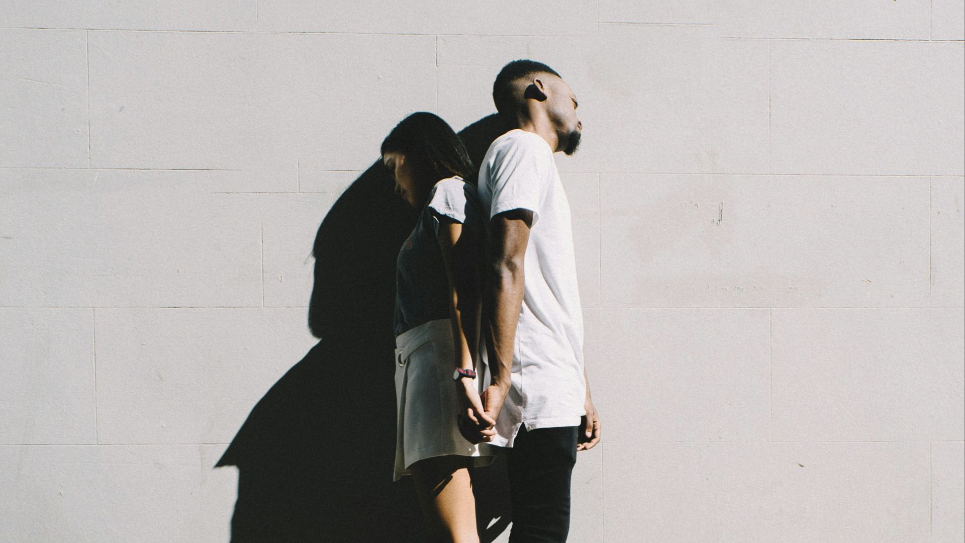 couple leaning on wall