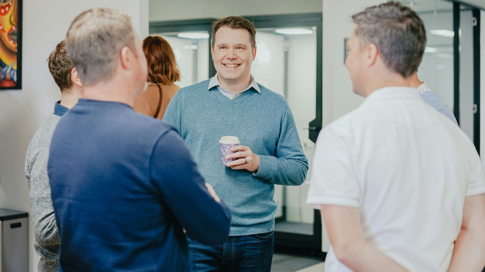 a group of people standing around talking to each other