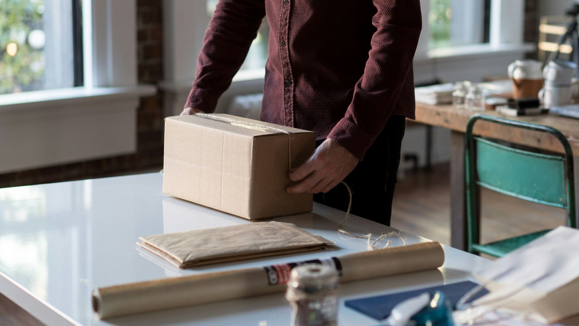 person holding cardboard box on table