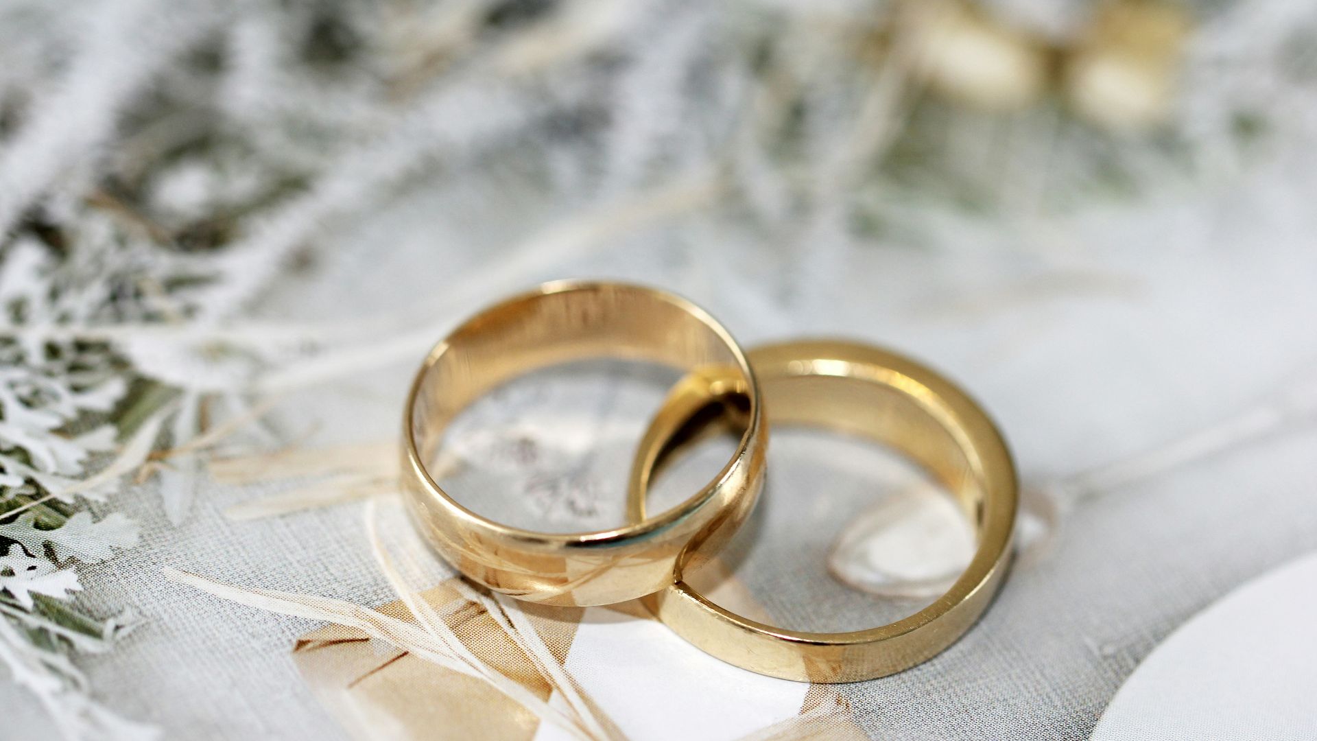 gold wedding band on white textile