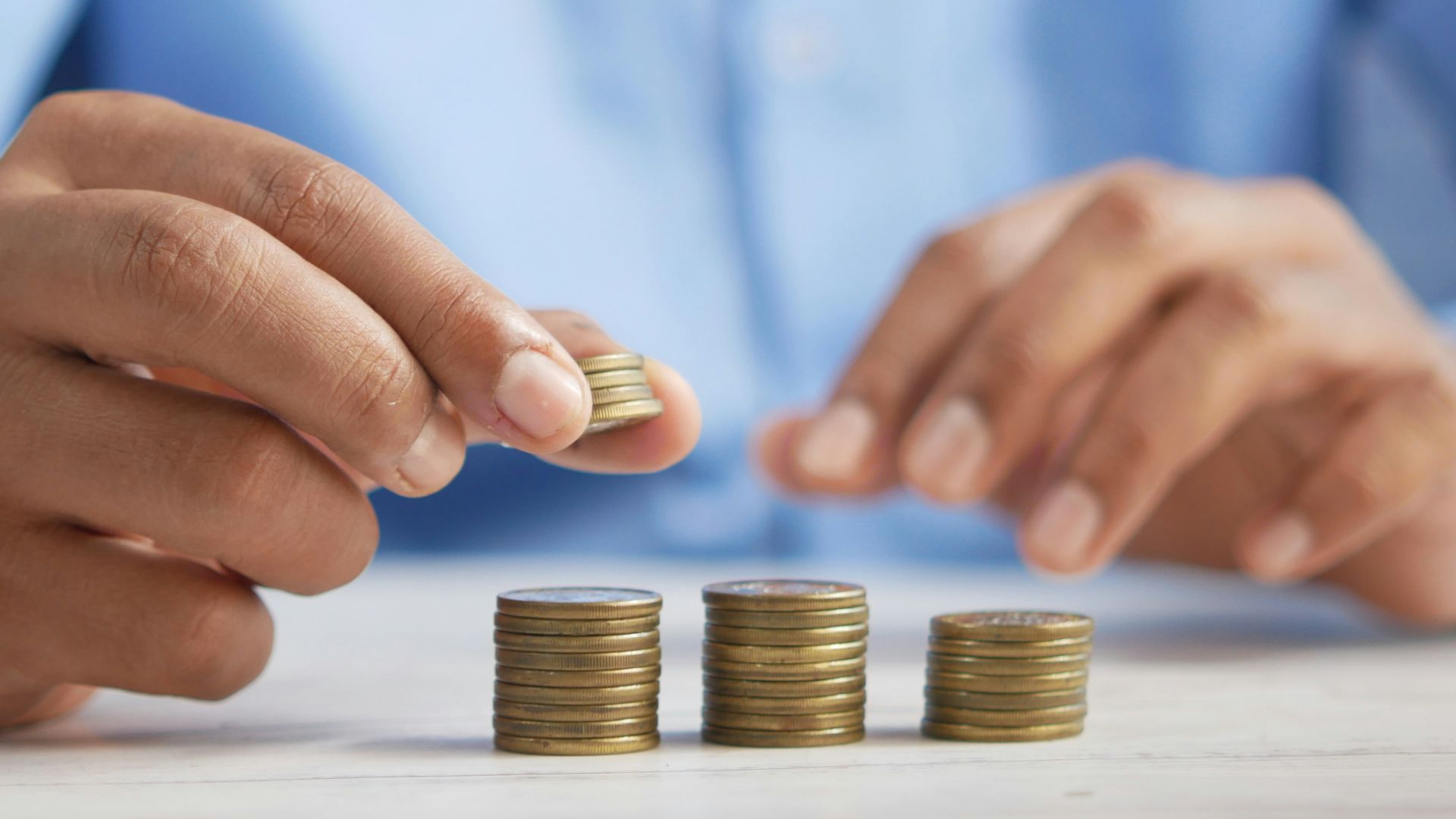 a person stacking coins on top of a table