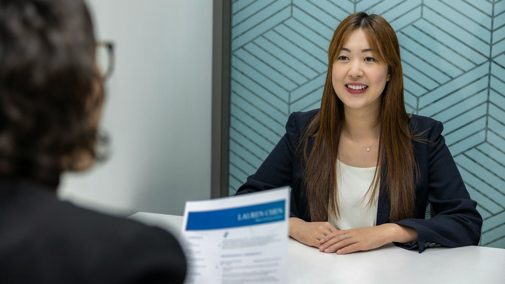 a woman sitting at a table with a piece of paper in front of her